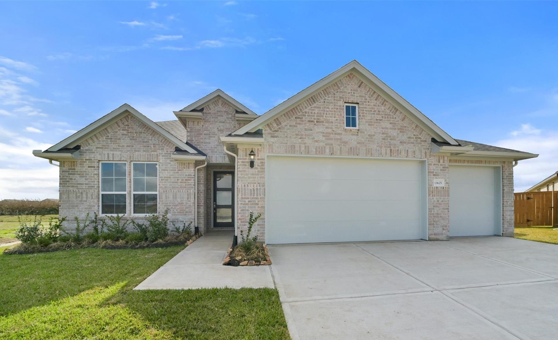 Brick two-story home with 3-car garage, gabled roof, and landscaped yard in Lago Mar, Texas City, Texas