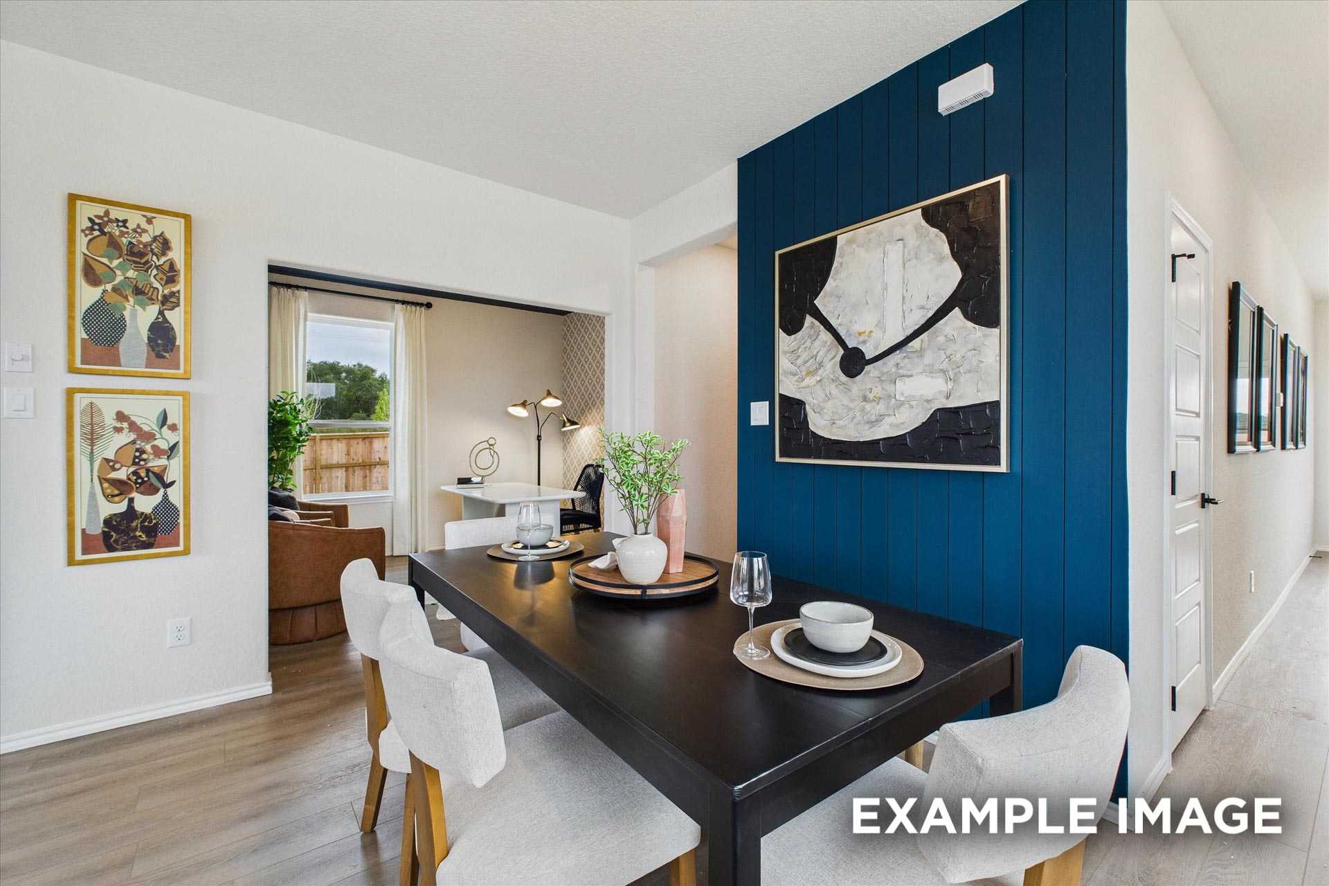 Elegant dining room with navy accent wall, abstract art, set table, and open layout in Davidson Homes The Florence C, San Antonio