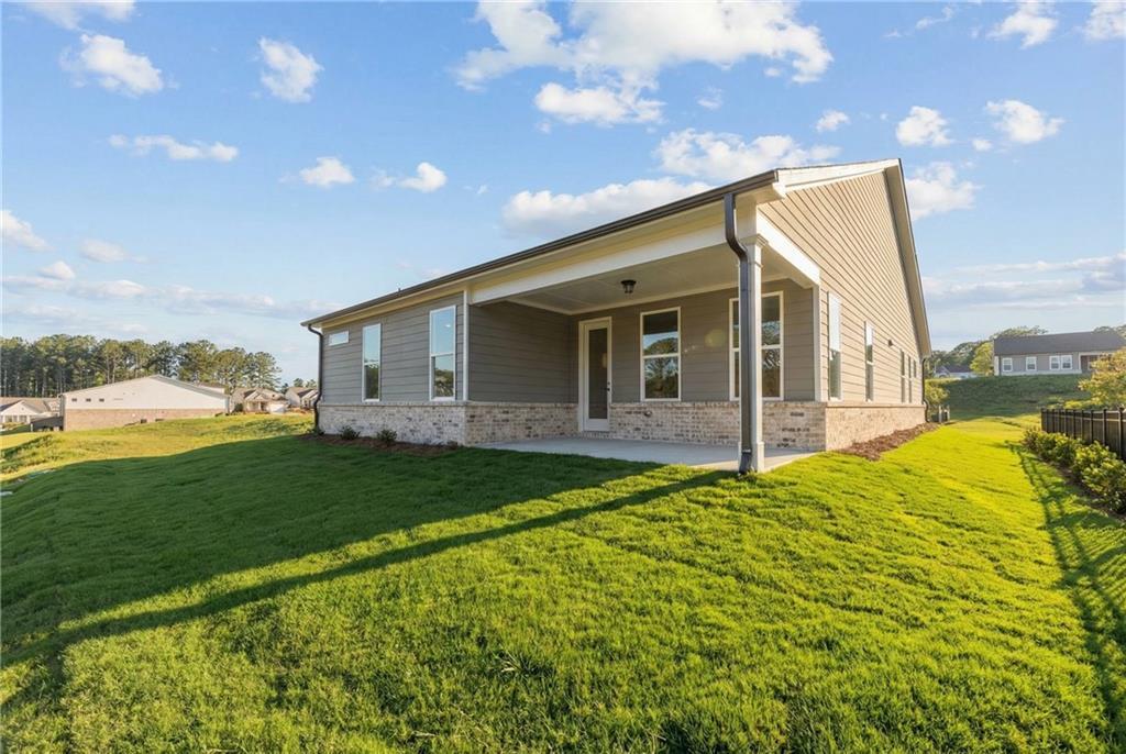 The Glenwood C single-story home by Davidson Homes with covered porch, brick accents, and lush green lawn in Kelly Preserve, Loganville, GA
