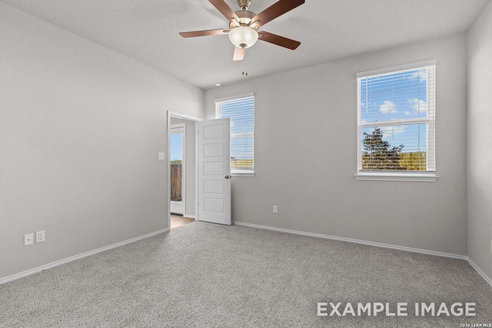 Bright bedroom with ceiling fan, large windows, neutral gray walls and carpet in 4-bedroom Davidson Homes The Colorado D, Agave San Antonio