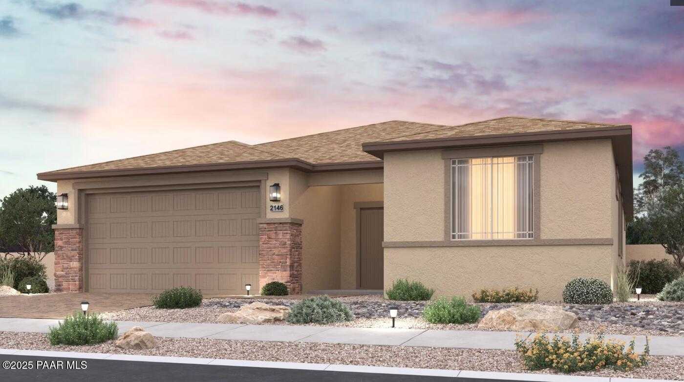 Beige single-story home with 3-car garage, desert landscaping, and sunset sky in North Ridge at Pronghorn Ranch, Prescott Valley, Arizona