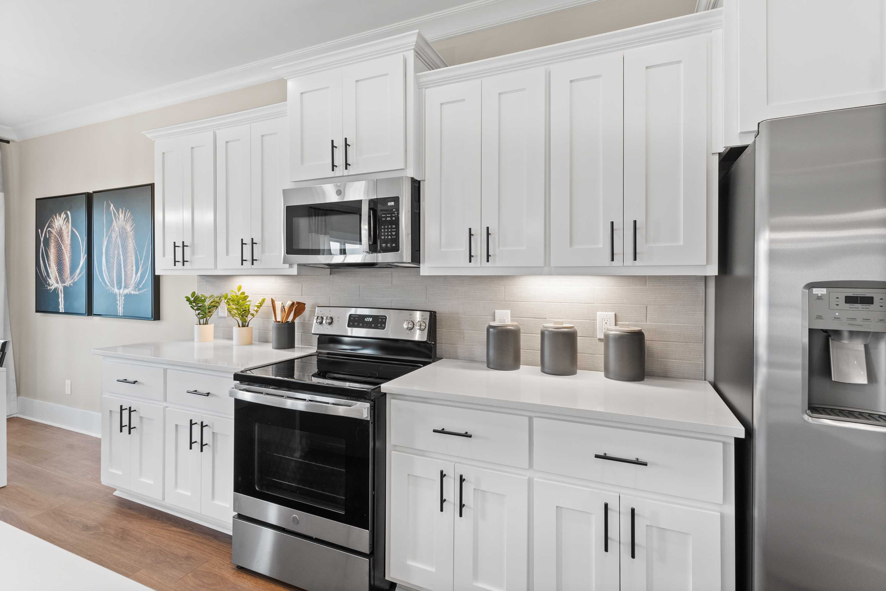 Modern kitchen in The Shelby A with white shaker cabinets, stainless steel appliances, and open counters