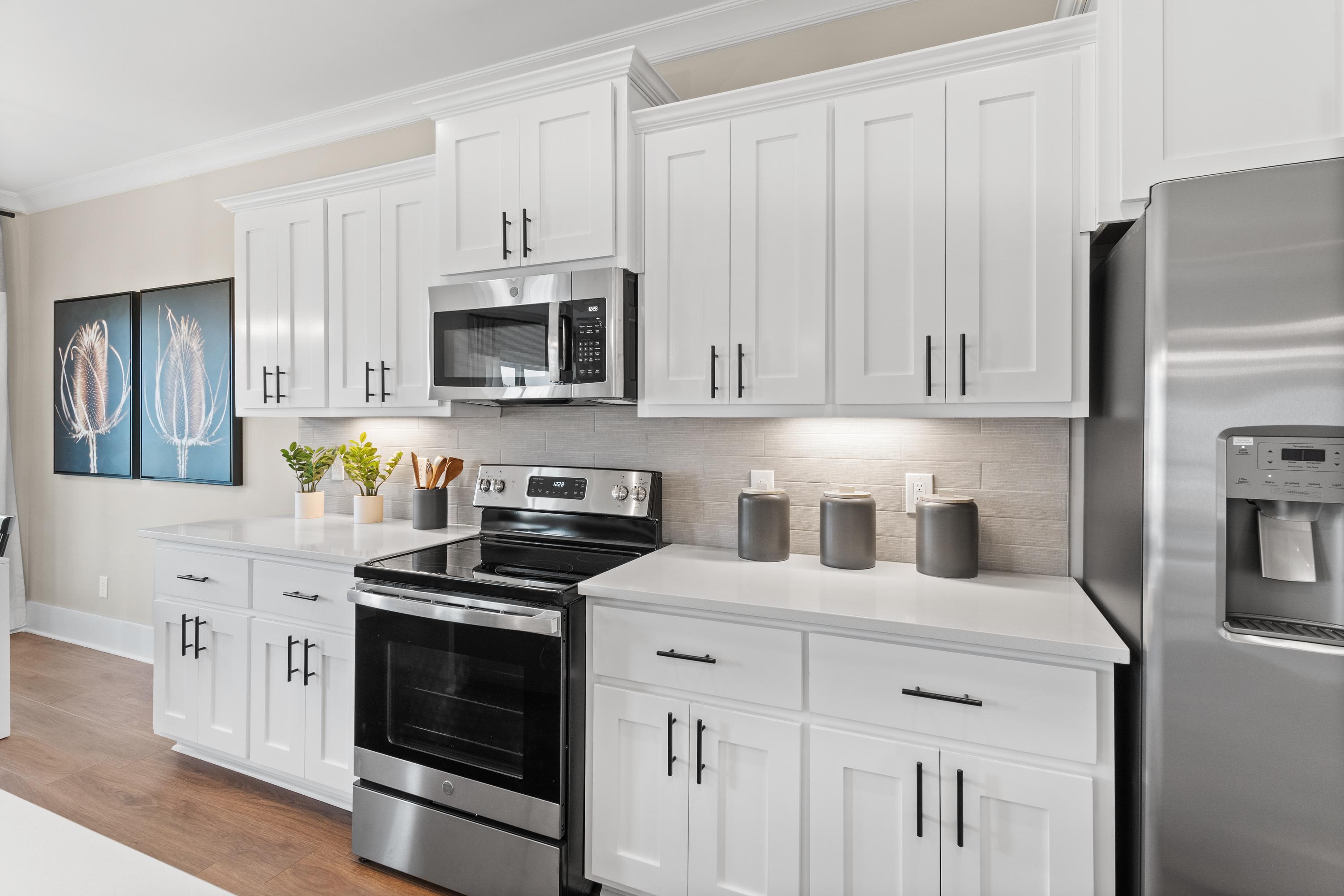 Modern kitchen in The Shelby A with white shaker cabinets, stainless steel appliances, and open counters