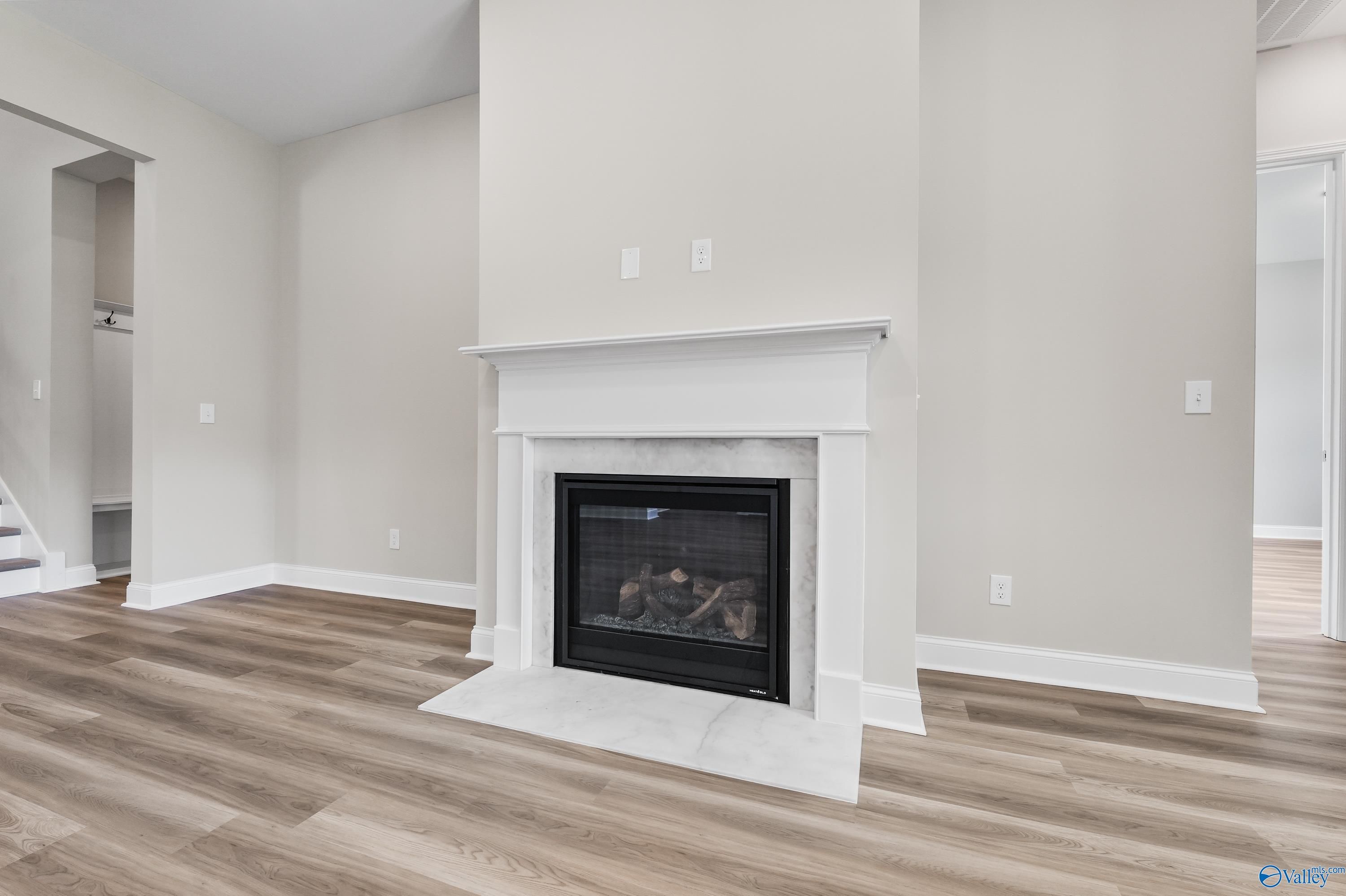 Elegant white mantel fireplace with gas logs in spacious family room of The Haven 5-bedroom home, Evermore Homes, Owens Cross Roads, Alabama