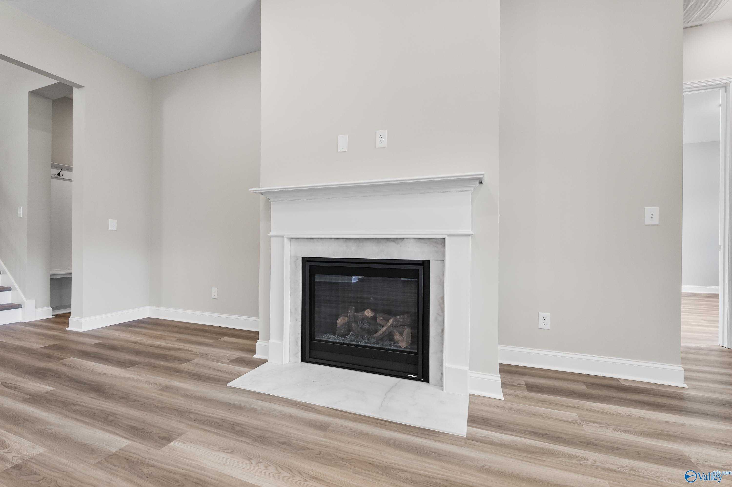 Elegant white mantel fireplace with gas logs in spacious family room of The Haven 5-bedroom home, Evermore Homes, Owens Cross Roads, Alabama