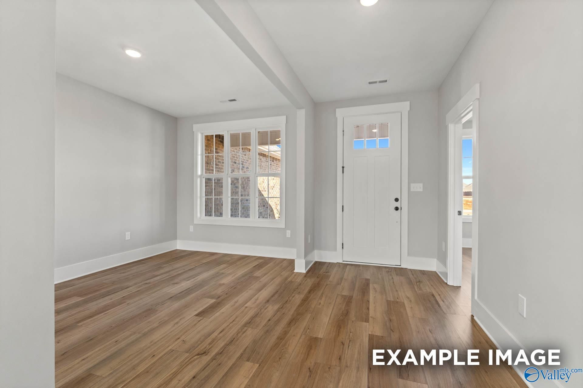 Bright foyer with wood-look flooring and white front door in The Finleigh floor plan at Briercreek in Meridianville, AL.