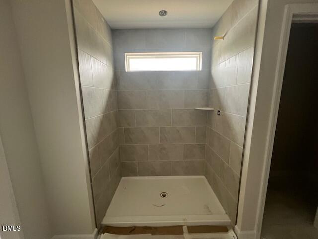 Spacious walk-in shower with subway tile walls, glass enclosure, and window in master bath of The Preston A by Davidson Homes, Lillington NC
