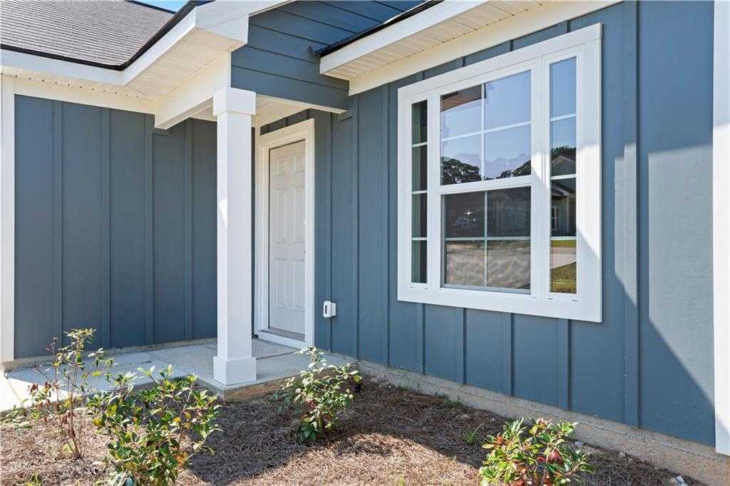 Charming blue-sided exterior with front porch, white door, and window on The Washington 3-bedroom home by Davidson Homes in Phenix City, Alabama