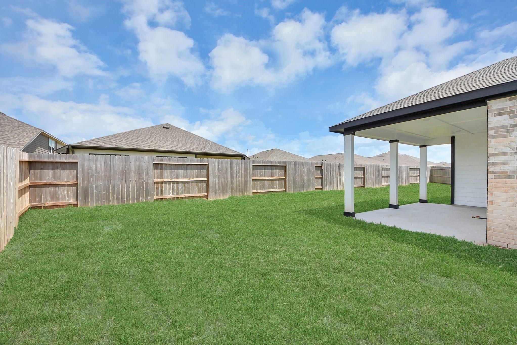 Private backyard with covered patio at The Verano B floor plan by Davidson Homes in Sunterra, Katy, Texas.