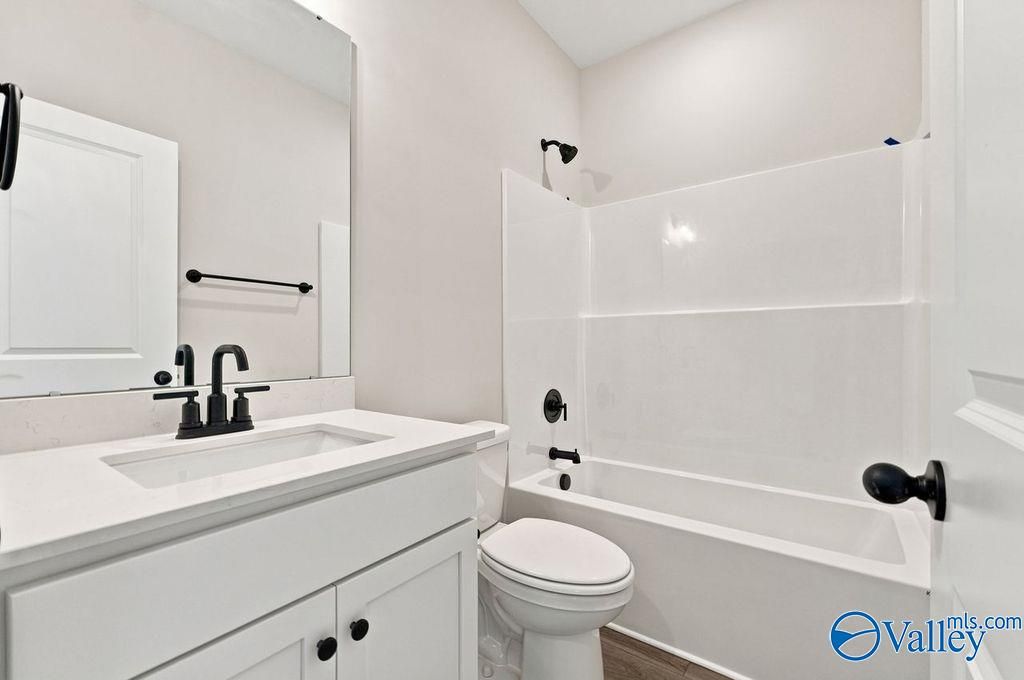 Modern bathroom with white vanity, black faucet, and tub-shower combo in The Camilla B floor plan at The Retreat at Cain Park.