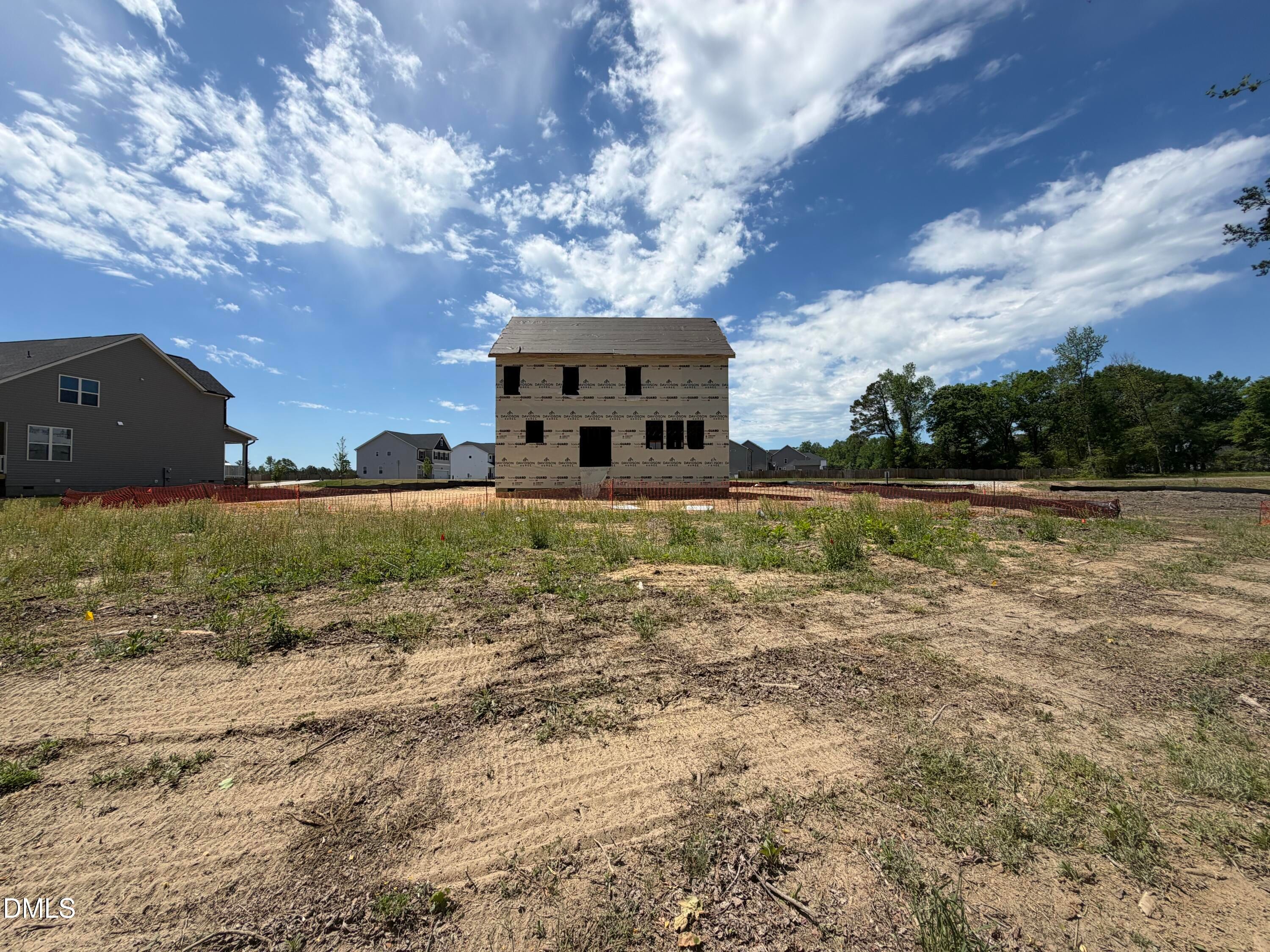 Two-story Hickory II C home under construction with house wrap, in Wellers Knoll, Lillington, North Carolina