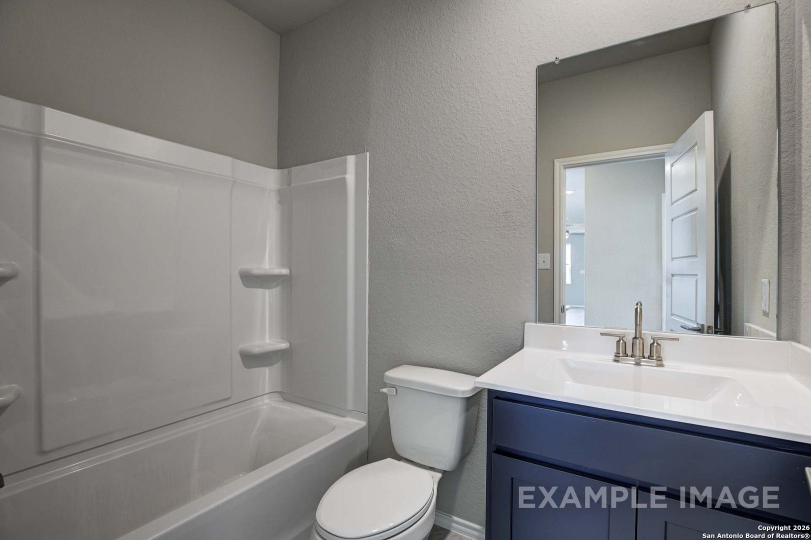 Modern guest bathroom featuring tub-shower combo, navy vanity, and gray walls in Davidson Homes The Frio B, San Antonio, Texas