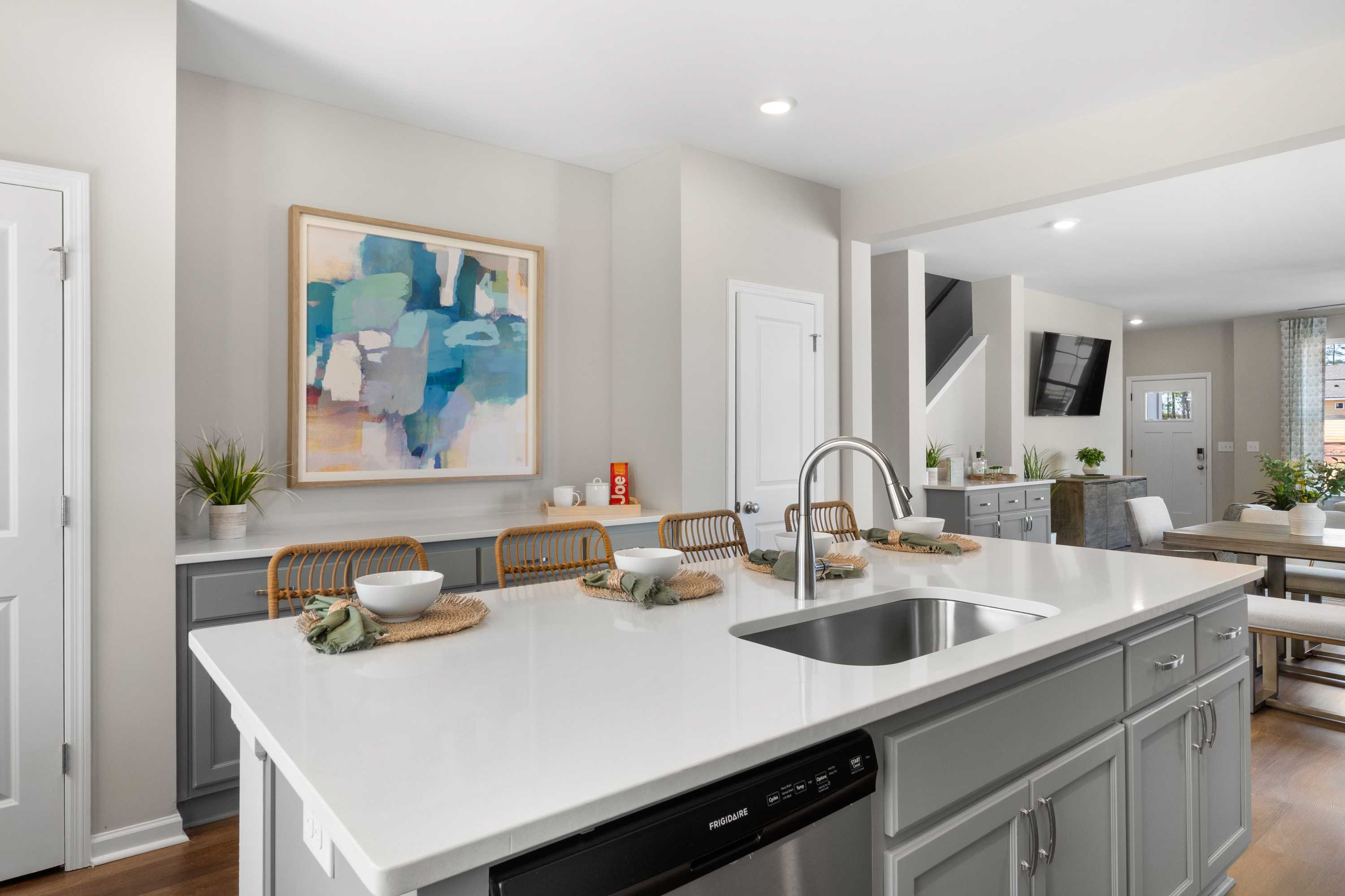 Modern open-concept kitchen in Evergreen Mill, Madison AL with white quartz island, gray shaker cabinets, and hardwood floors