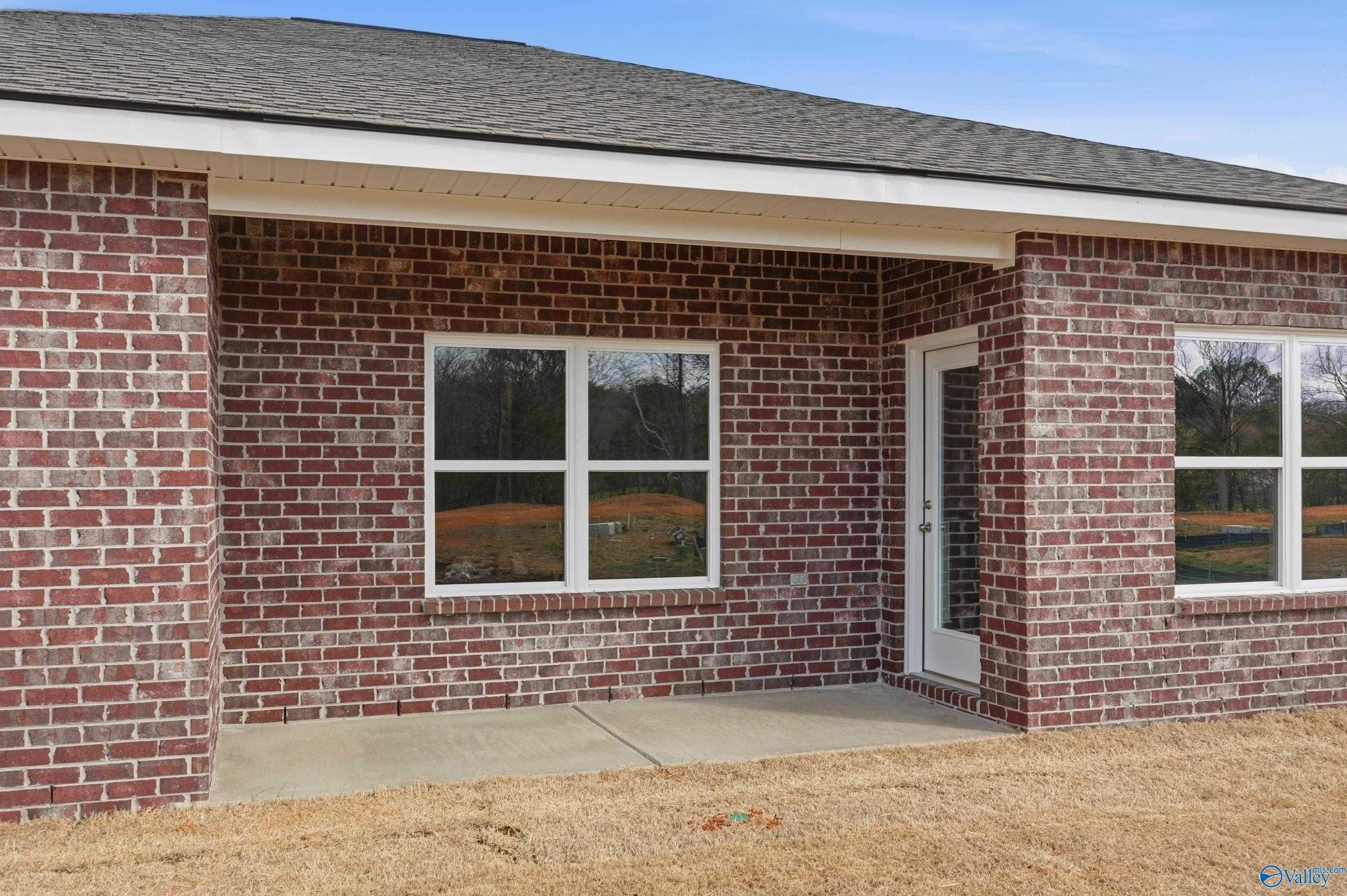 Brick 3-bedroom home exterior with 2-car garage, large windows, and covered entry in Spragins Cove, Huntsville, AL