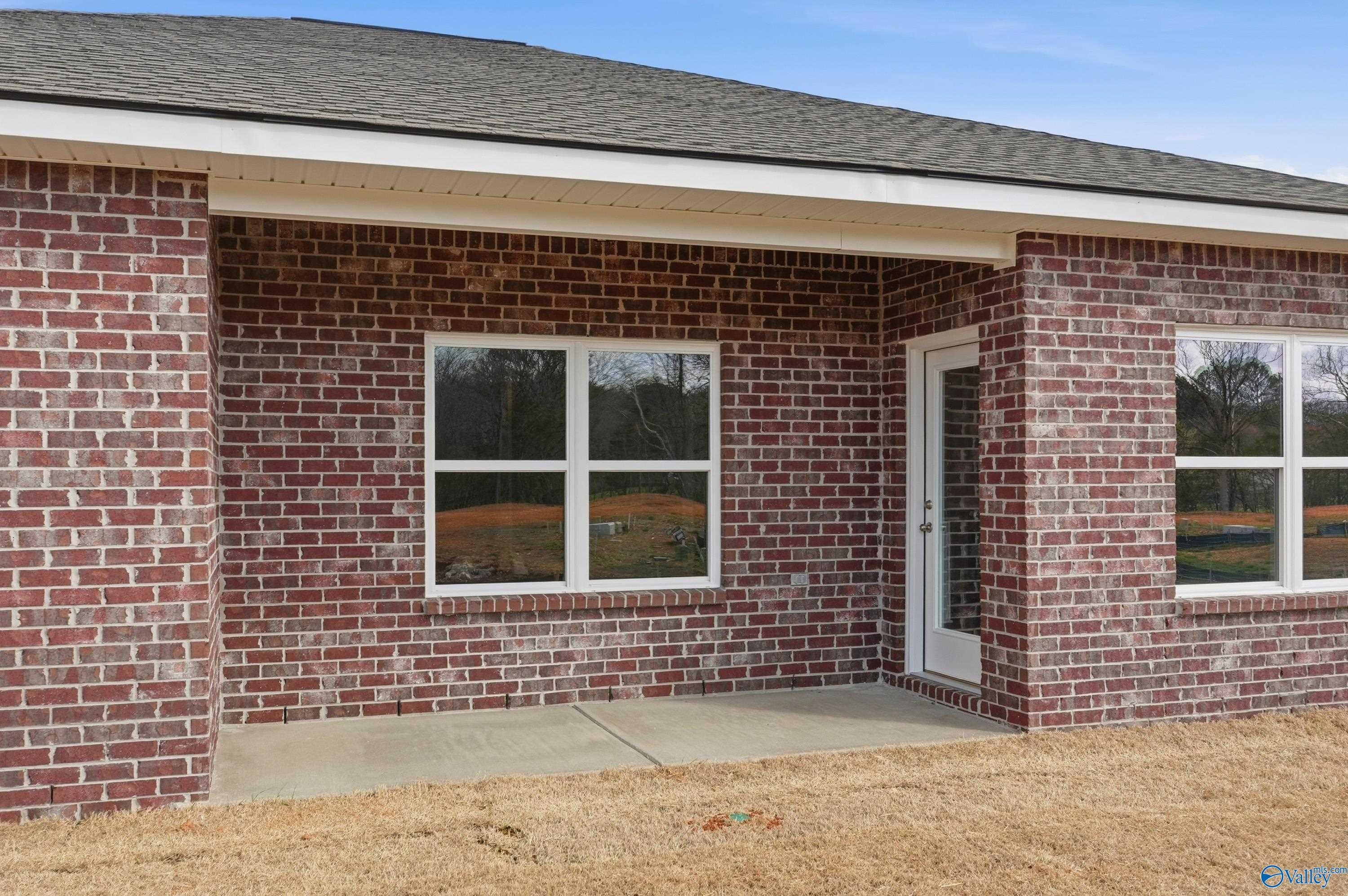 Brick 3-bedroom home exterior with 2-car garage, large windows, and covered entry in Spragins Cove, Huntsville, AL