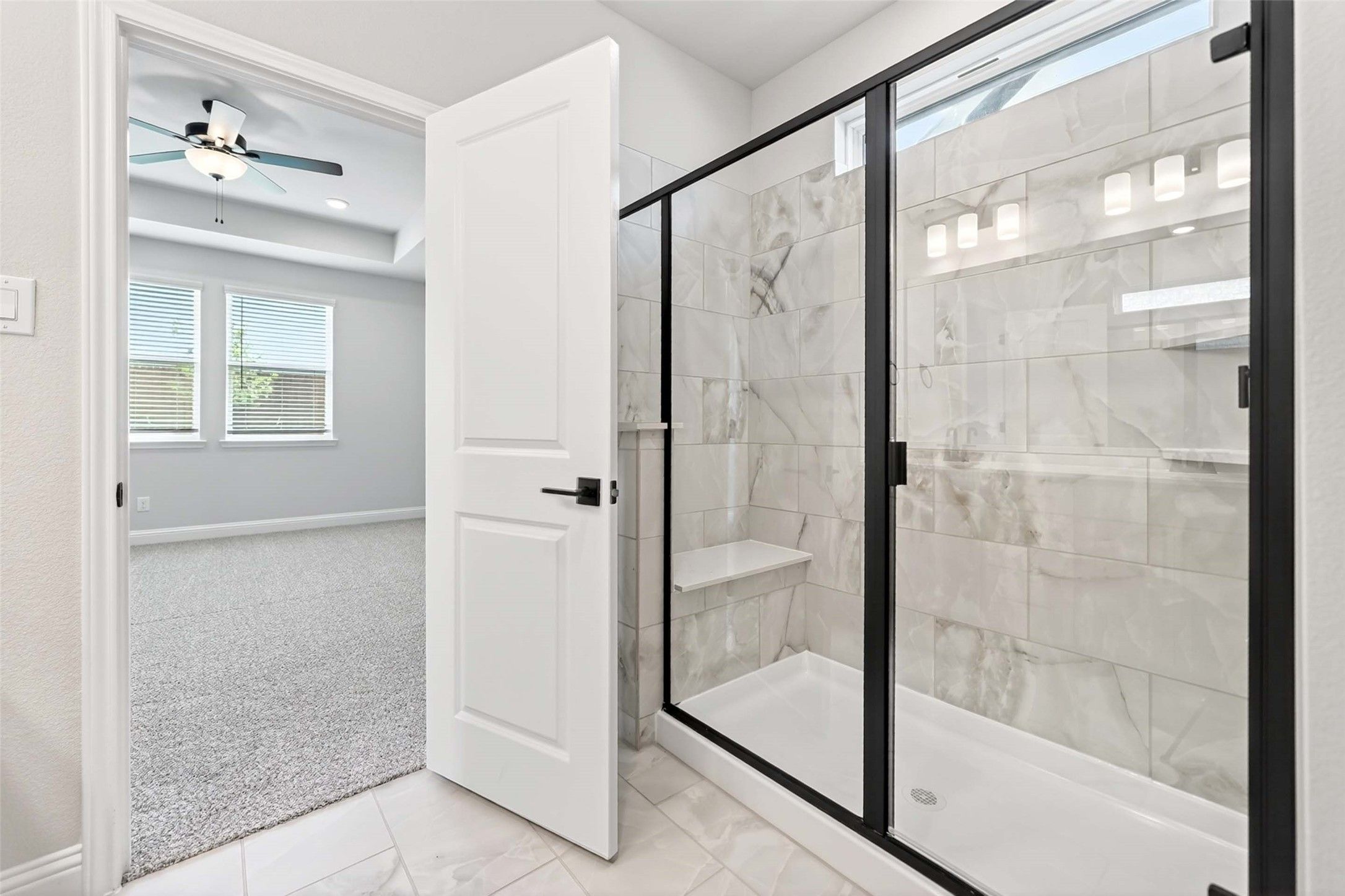 Modern bathroom with tiled walk-in shower and black frame in The Holly C floor plan at Parks at Foster Crossing, Anna, TX.