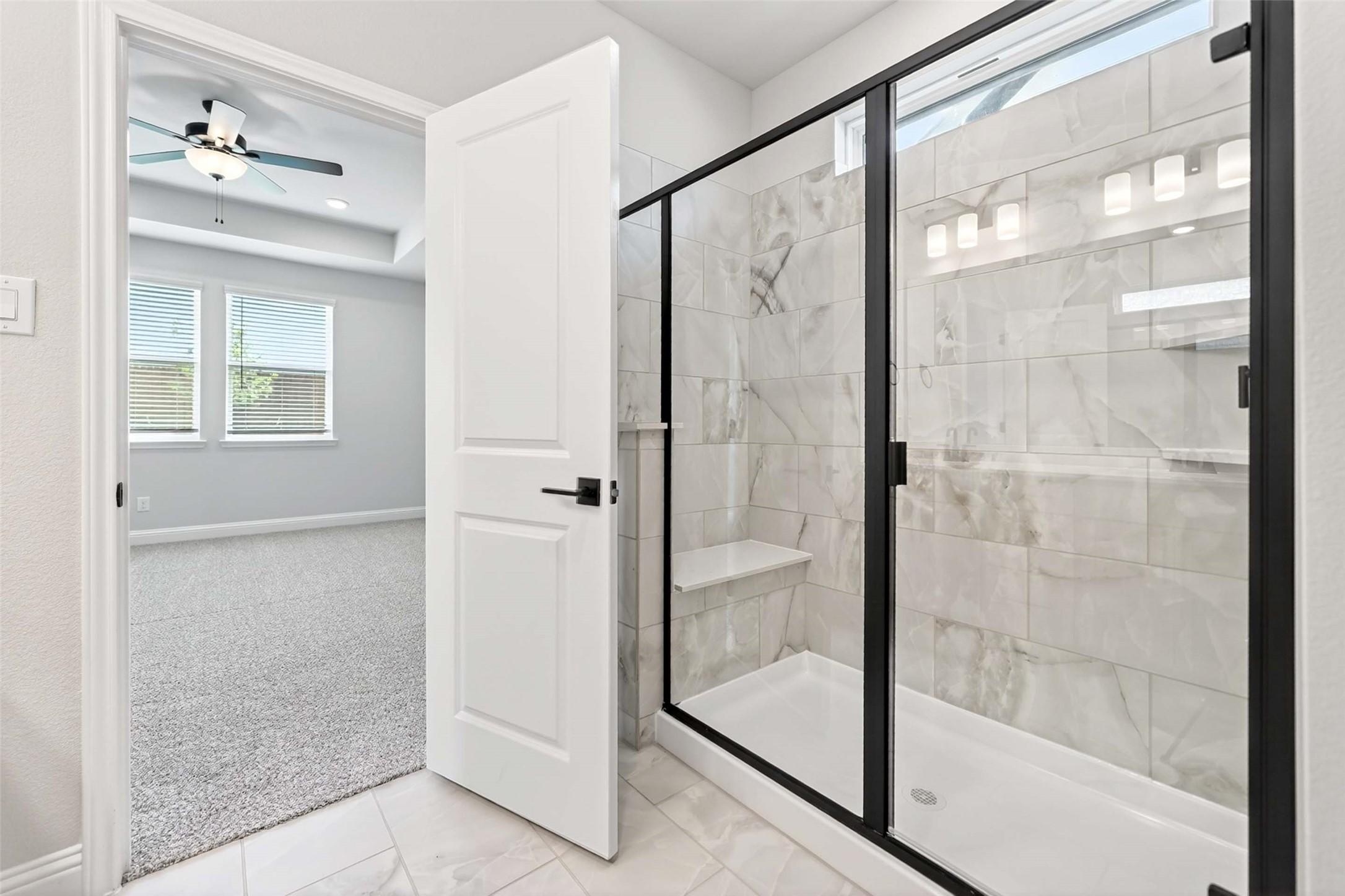 Modern bathroom with tiled walk-in shower and black frame in The Holly C floor plan at Parks at Foster Crossing, Anna, TX.