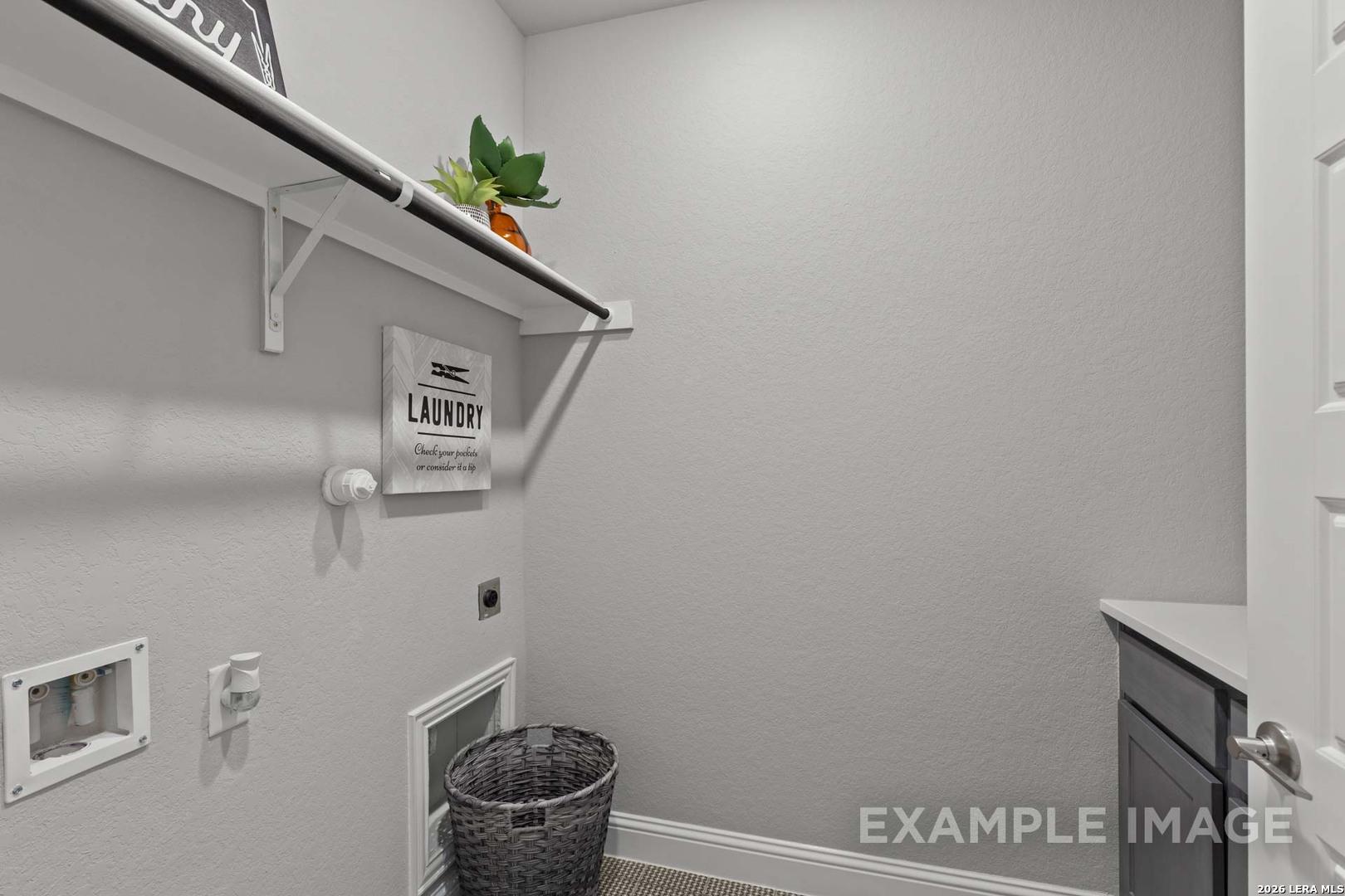 Laundry room with storage shelf and wicker basket in The Garner C floor plan at The Reserve at Potranco Oaks, Texas.