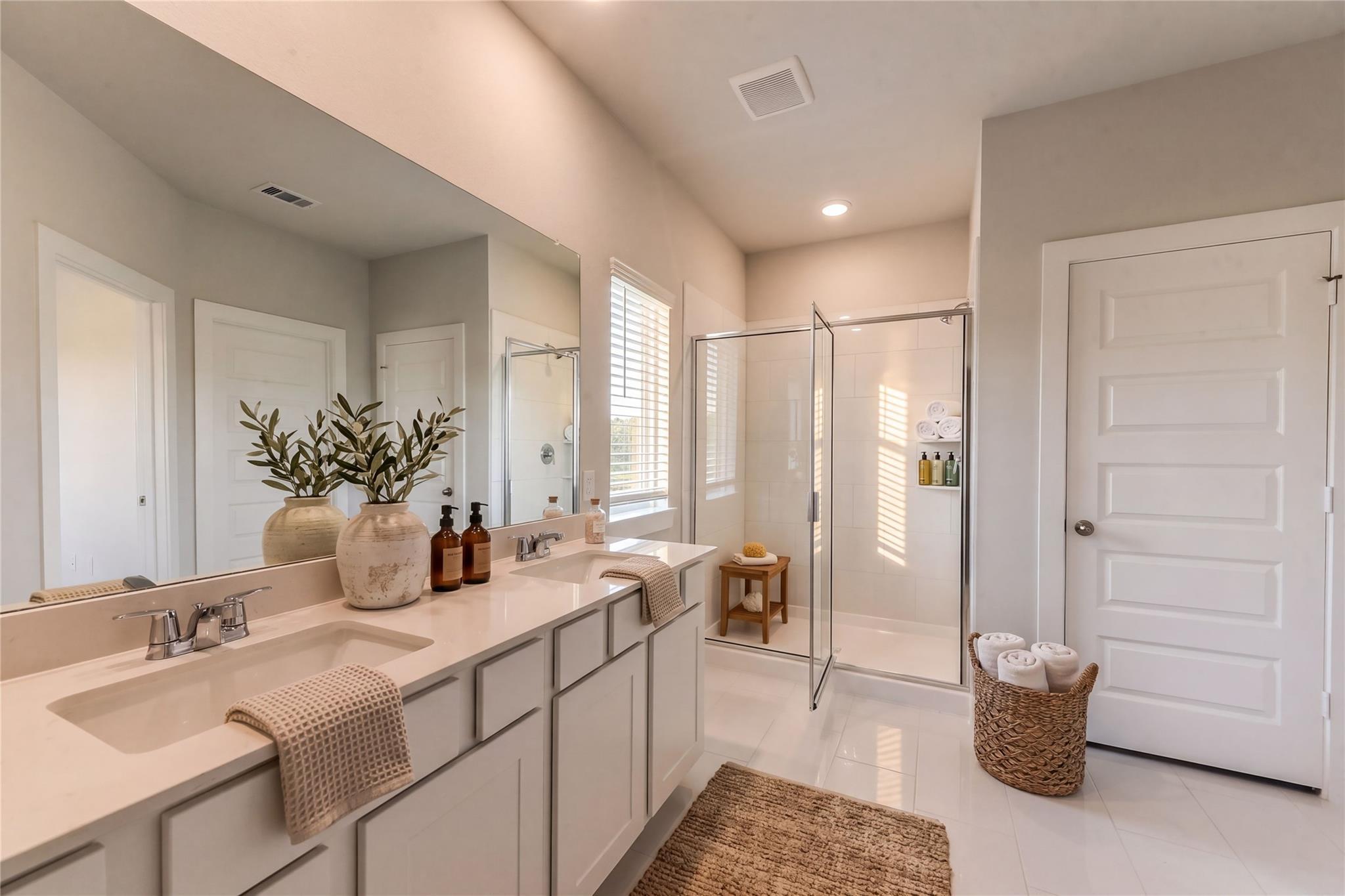 Modern master bathroom featuring double vanity, glass shower, and olive branch decor in Davidson Homes The Costa C, Dayton, Texas