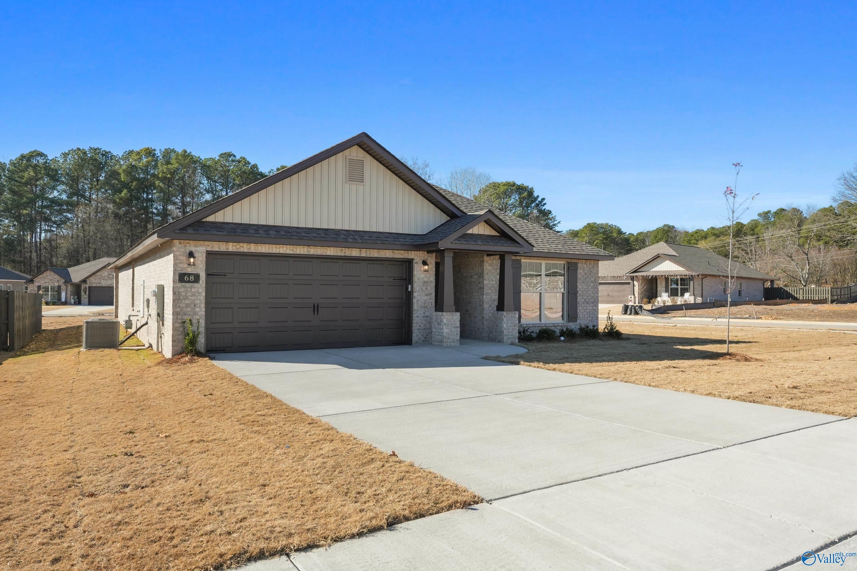 Single-story beige 4-bedroom home with 2-car garage and driveway in The Highlands, Arab, Alabama by Davidson Homes