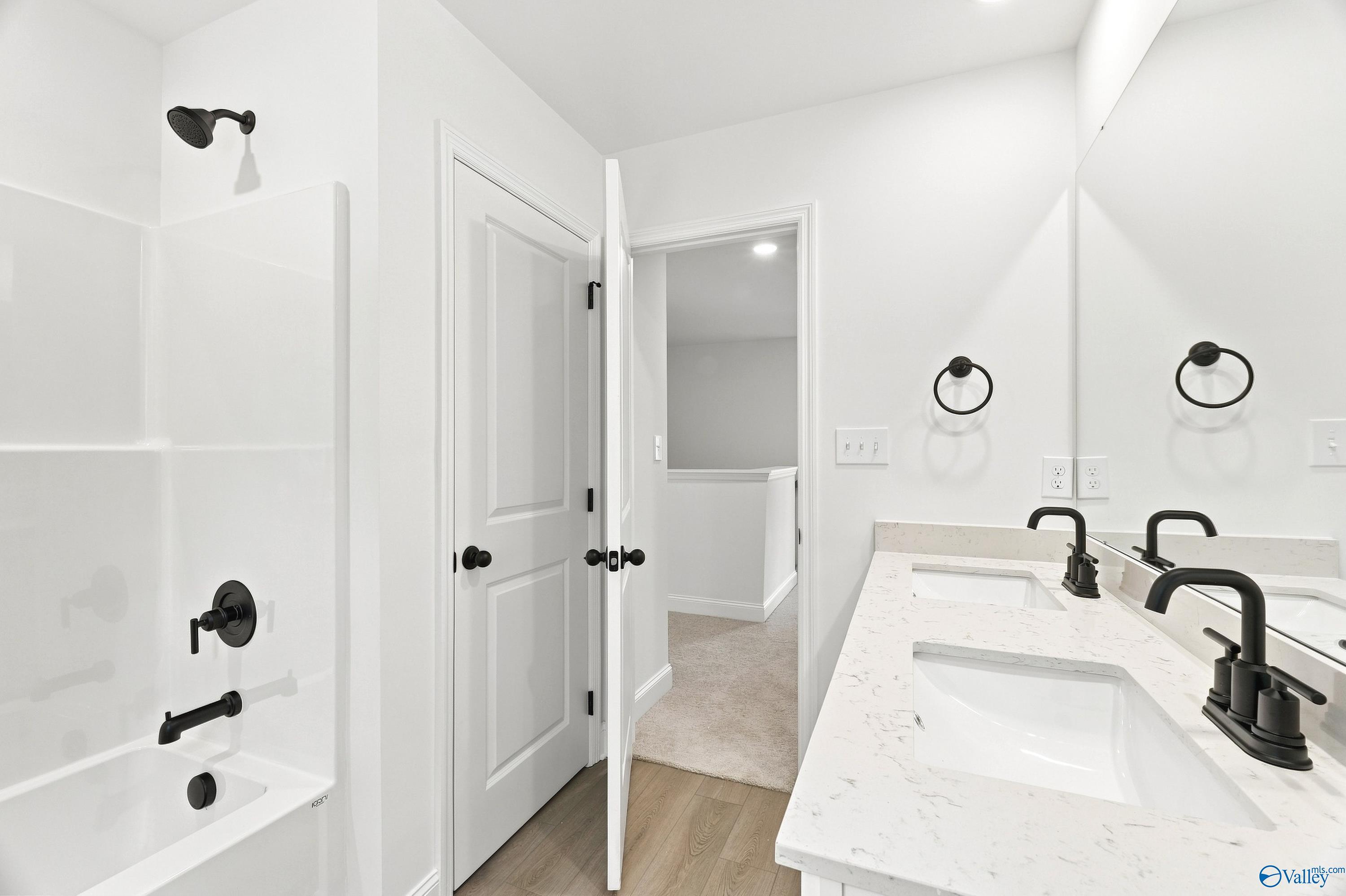 Modern bathroom with double vanity, quartz countertops, and matte black fixtures in The Shelby B home, Jaguar Hills.