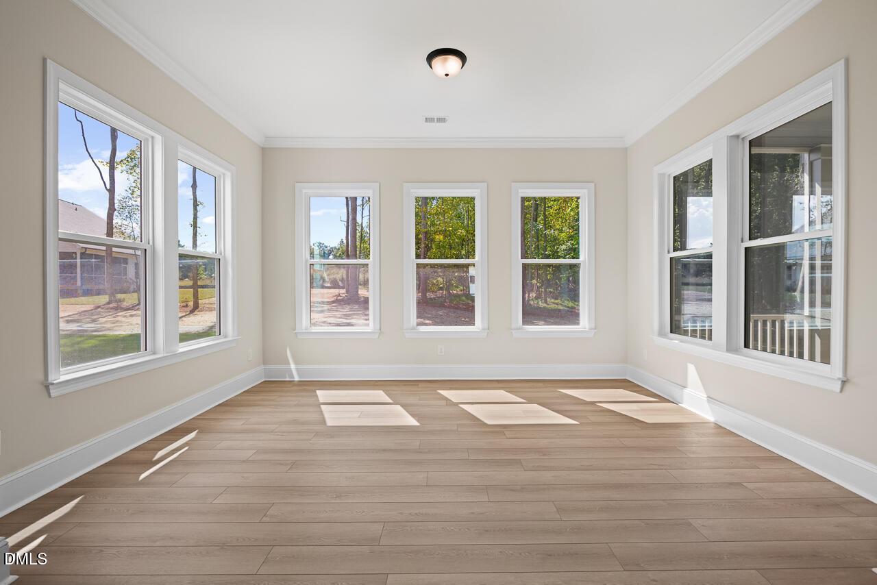 Sunlit empty room with luxury vinyl plank flooring and multiple windows in Davidson Homes The Crawford D floor plan, Wake Forest, NC