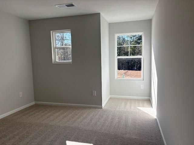 Bright secondary bedroom with gray walls, carpet flooring, and sunny windows in Davidson Homes Marion A, Winder, Georgia