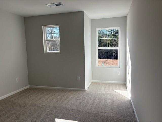 Bright secondary bedroom with gray walls, carpet flooring, and sunny windows in Davidson Homes Marion A, Winder, Georgia