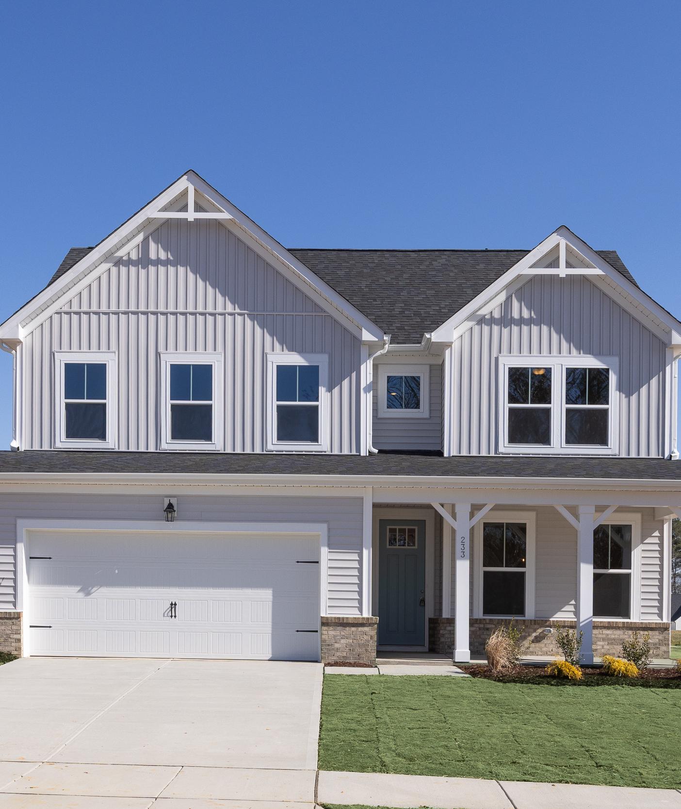 Two-story Davidson Homes exterior at Woodland Crossing in Zebulon, NC with board and batten siding and front porch.