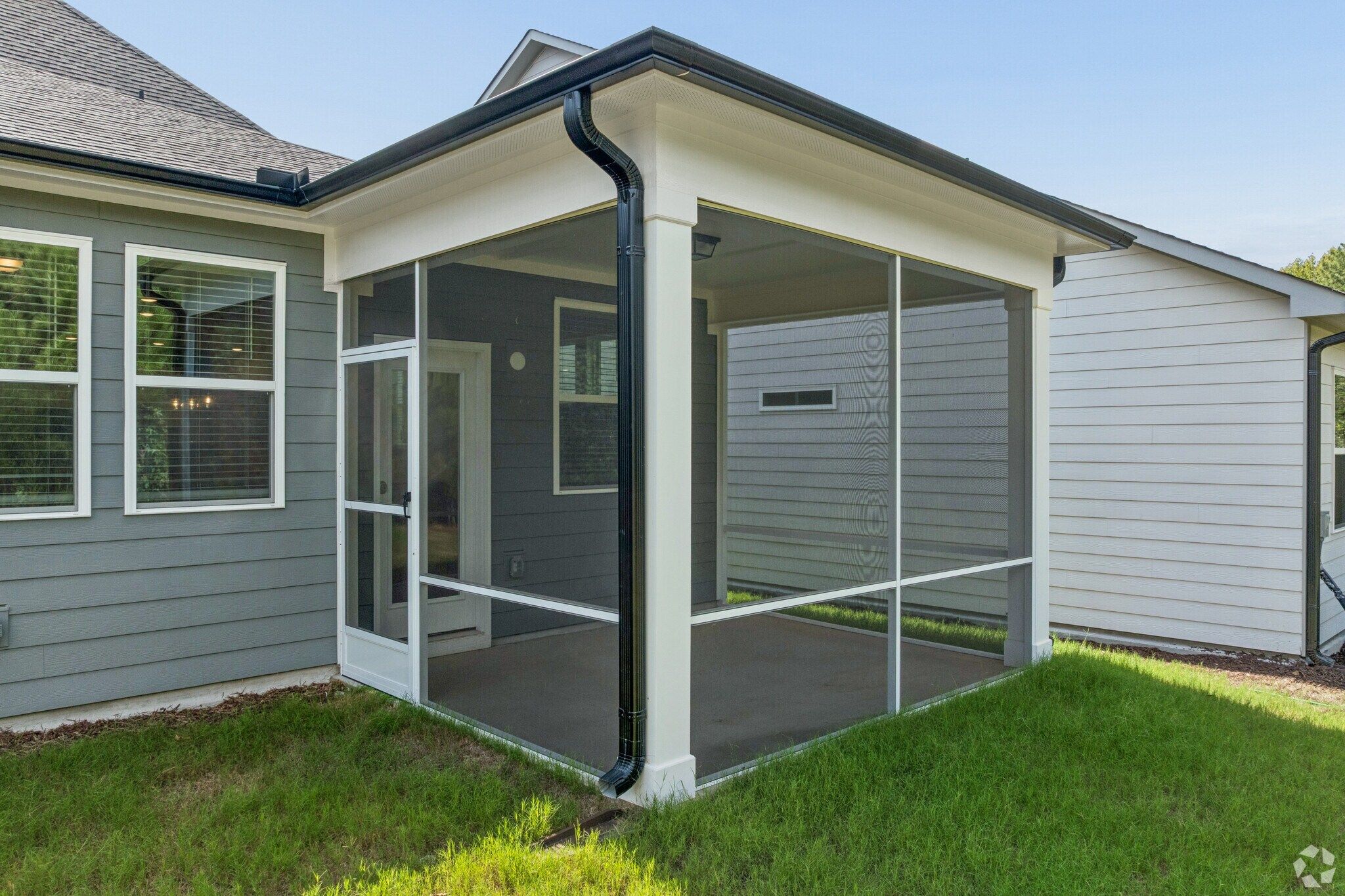 Screened-in back porch at Sage on North Main in Wake Forest, NC by Davidson Homes with gray siding and white trim