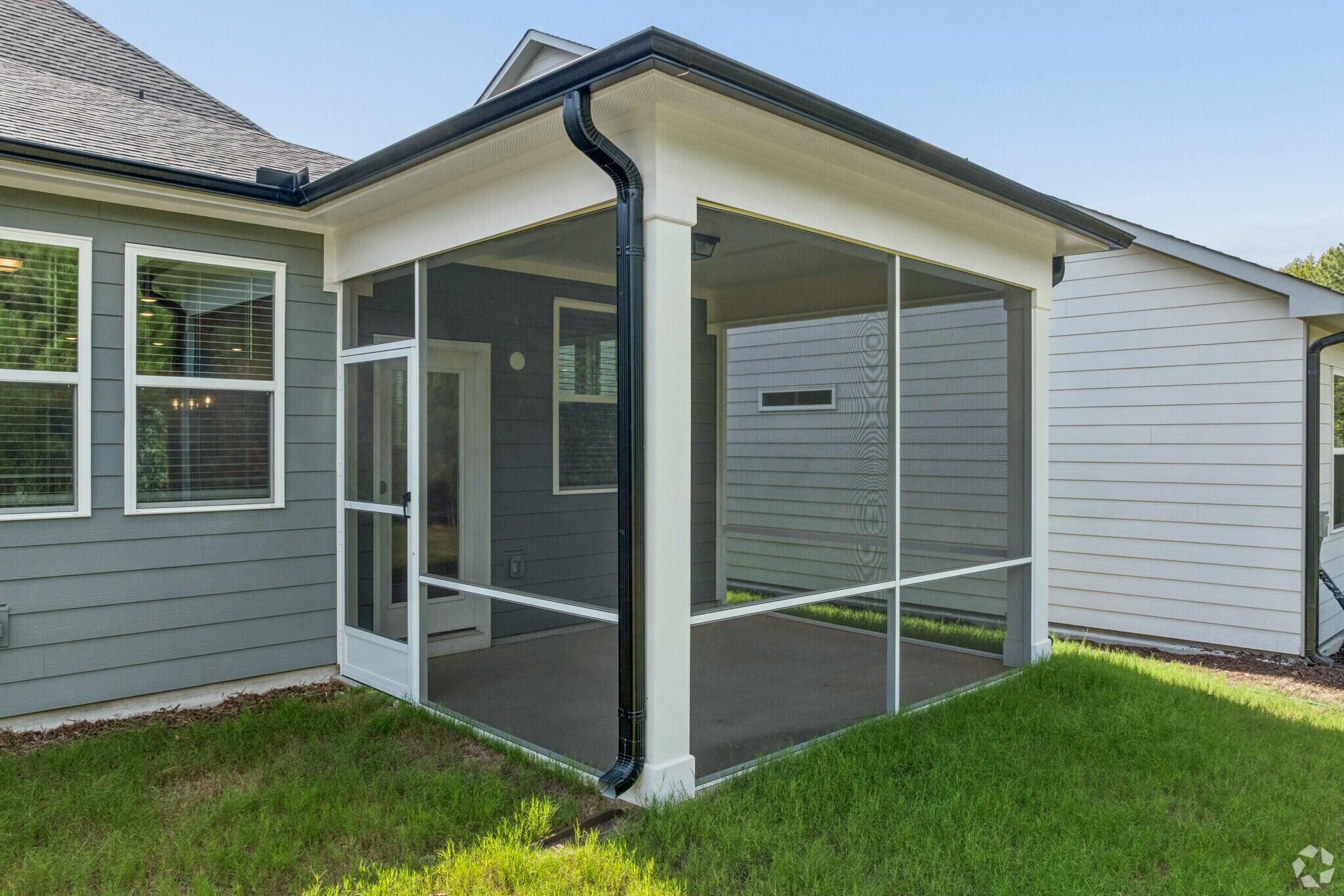 Screened-in back porch at Sage on North Main in Wake Forest, NC by Davidson Homes with gray siding and white trim