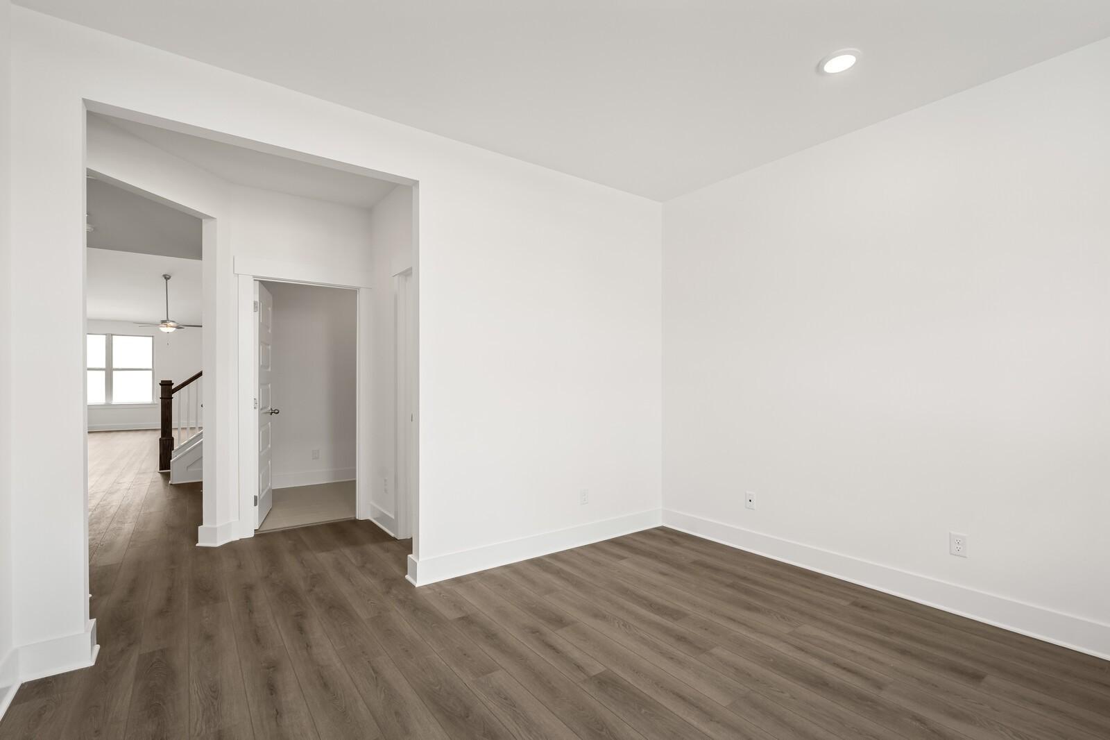 Bright, spacious room with wood-style flooring in The Ridgeport C floor plan at Woods Crossing in Gallatin, Tennessee.