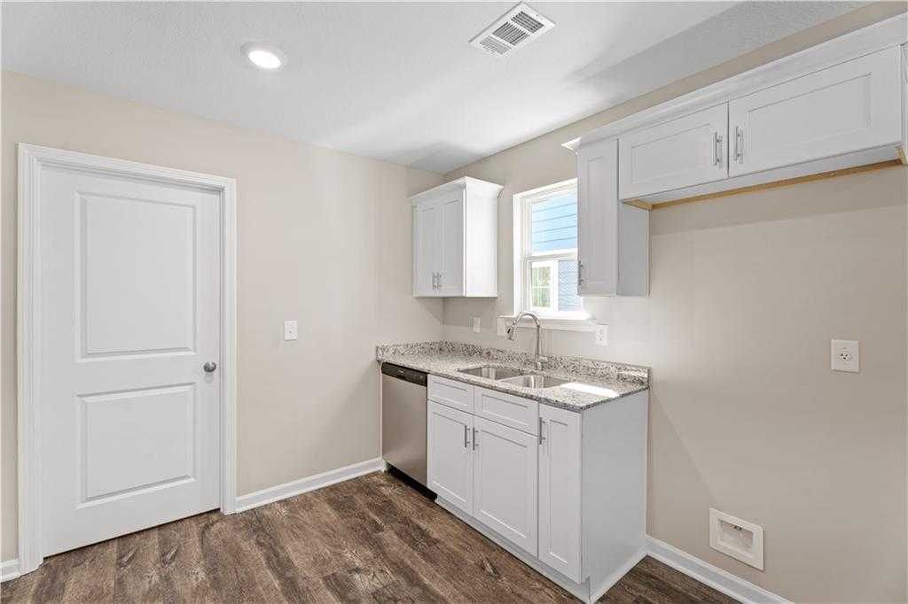 Bright kitchen with white shaker cabinets, stainless dishwasher, granite counters in Davidson Homes The Washington, Phenix City