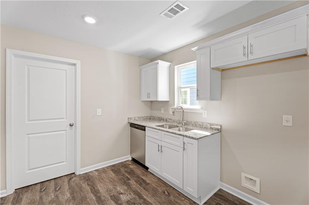 Bright kitchen with white shaker cabinets, stainless dishwasher, granite counters in Davidson Homes The Washington, Phenix City