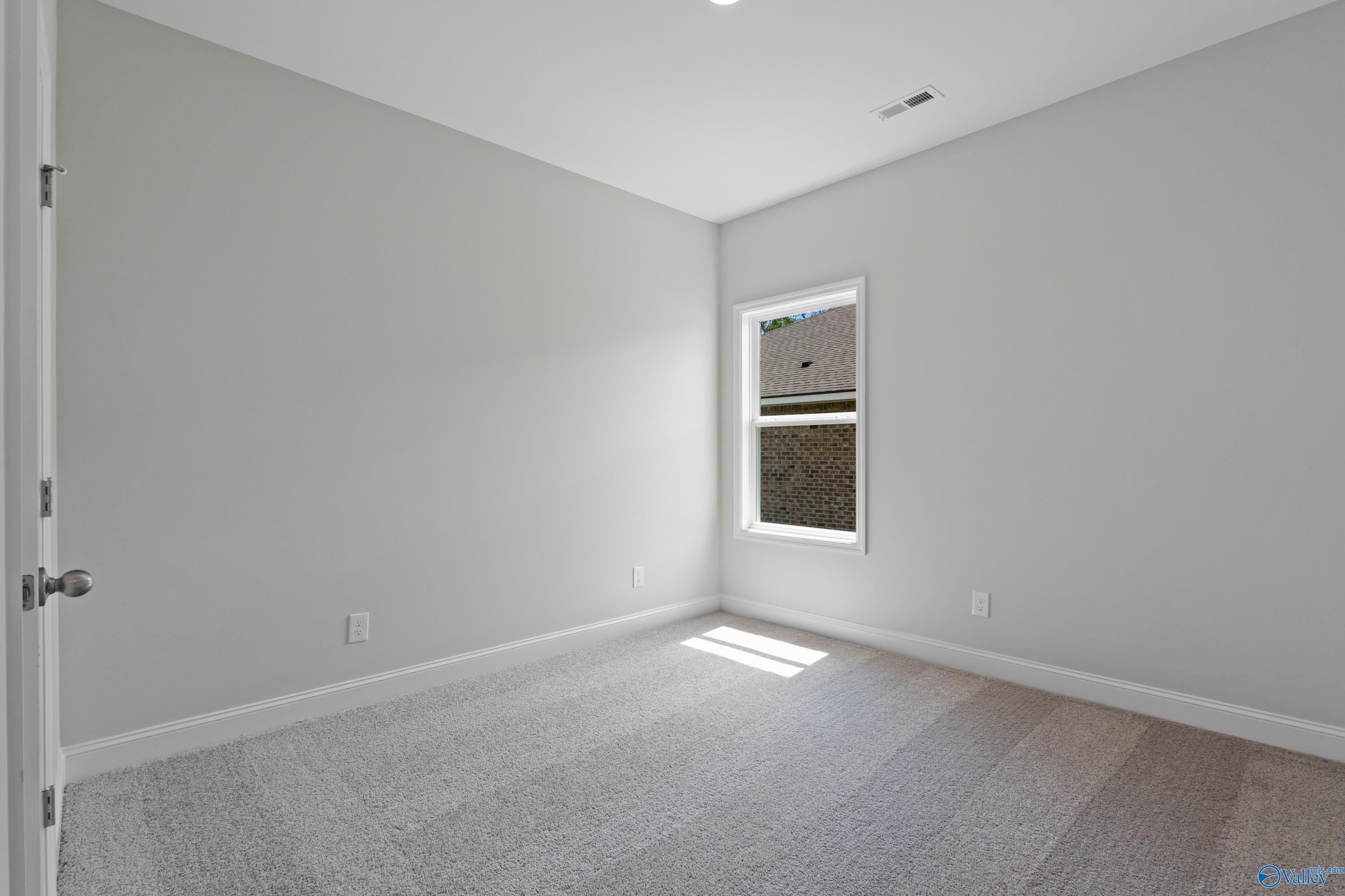 Empty bedroom with light gray walls, beige carpet floor, double window with blinds in The Asheville floor plan, Davidson Homes, Huntsville AL