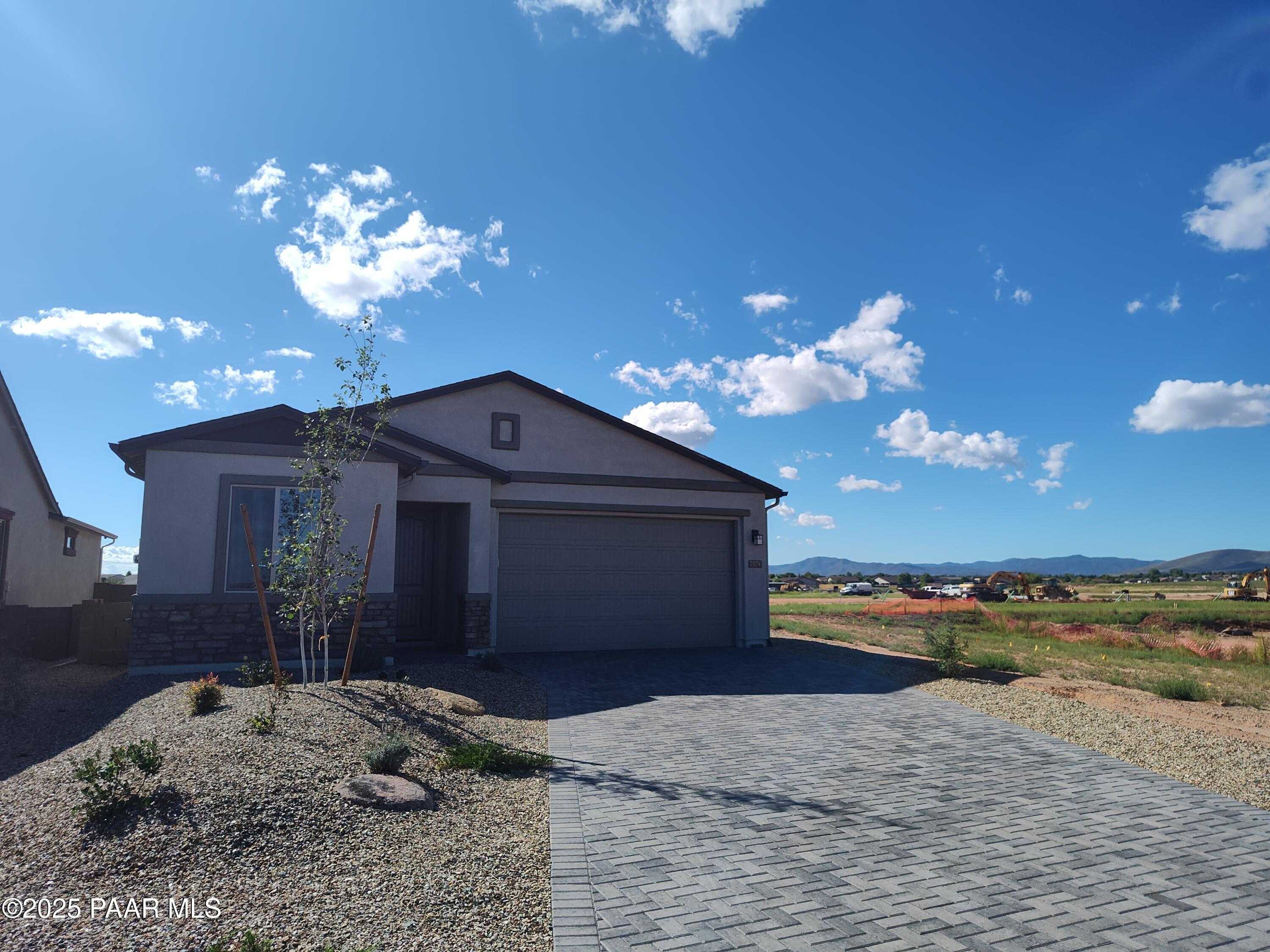 Modern single-story Frontier A home with 3-car garage, stone accents, and desert landscape in North Ridge at Pronghorn Ranch, Prescott Valley, Arizona