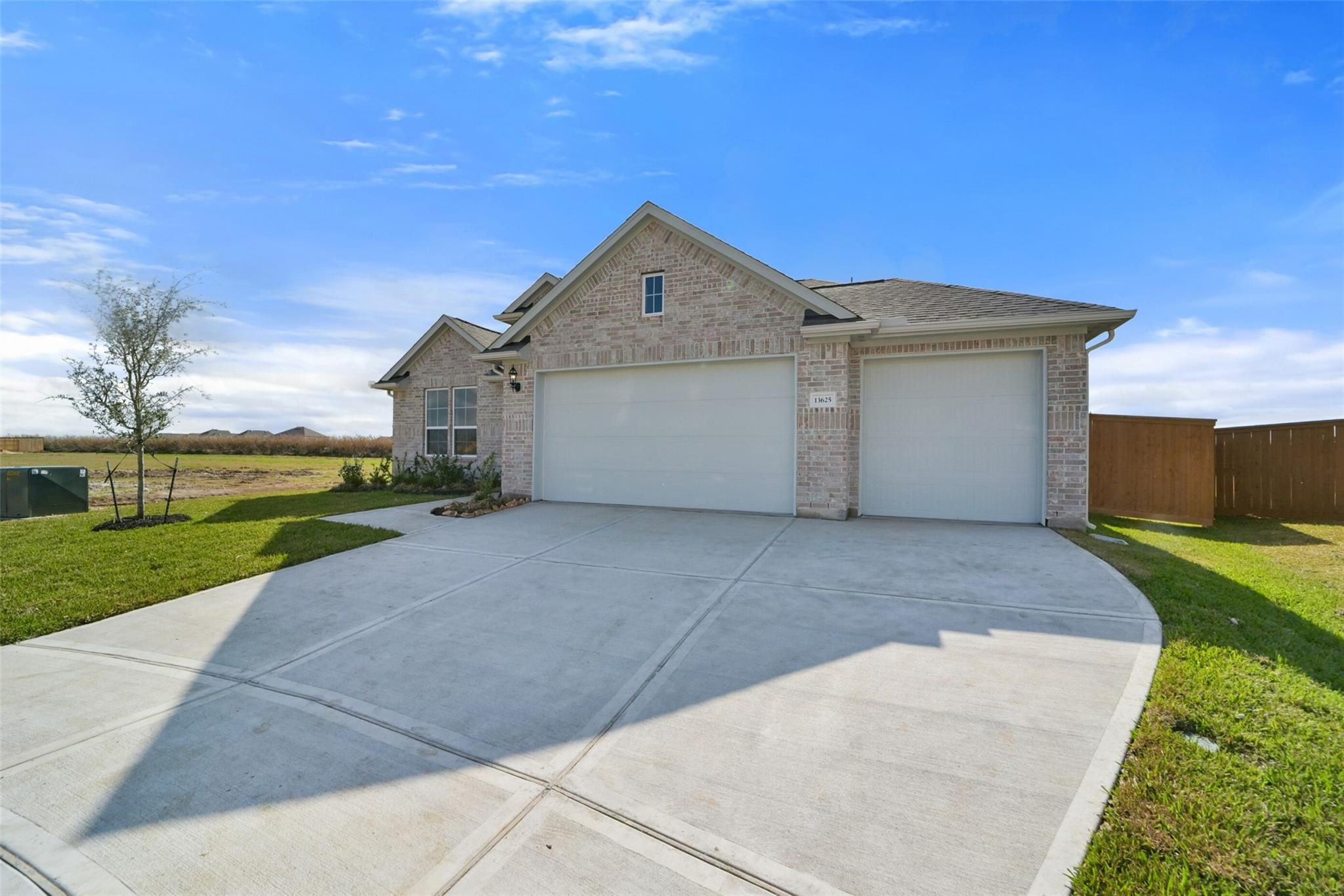 Two-story brick home with 3-car garage, concrete driveway, and green lawn in Lago Mar, Texas City, Texas - Davidson Homes Zion A