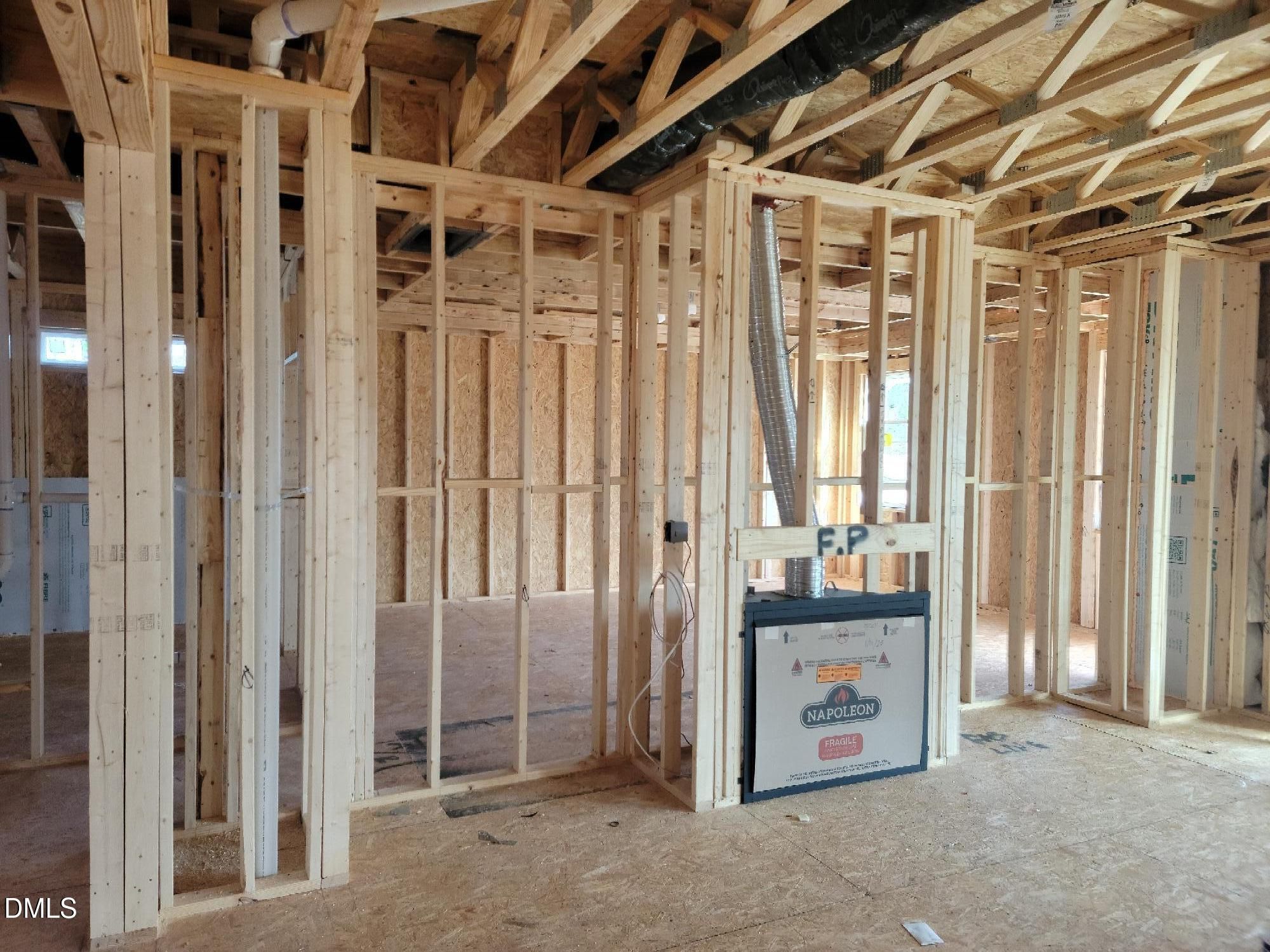 Exposed wooden framing and fireplace unit in The Cypress B II 4-bedroom home construction, Angier, North Carolina