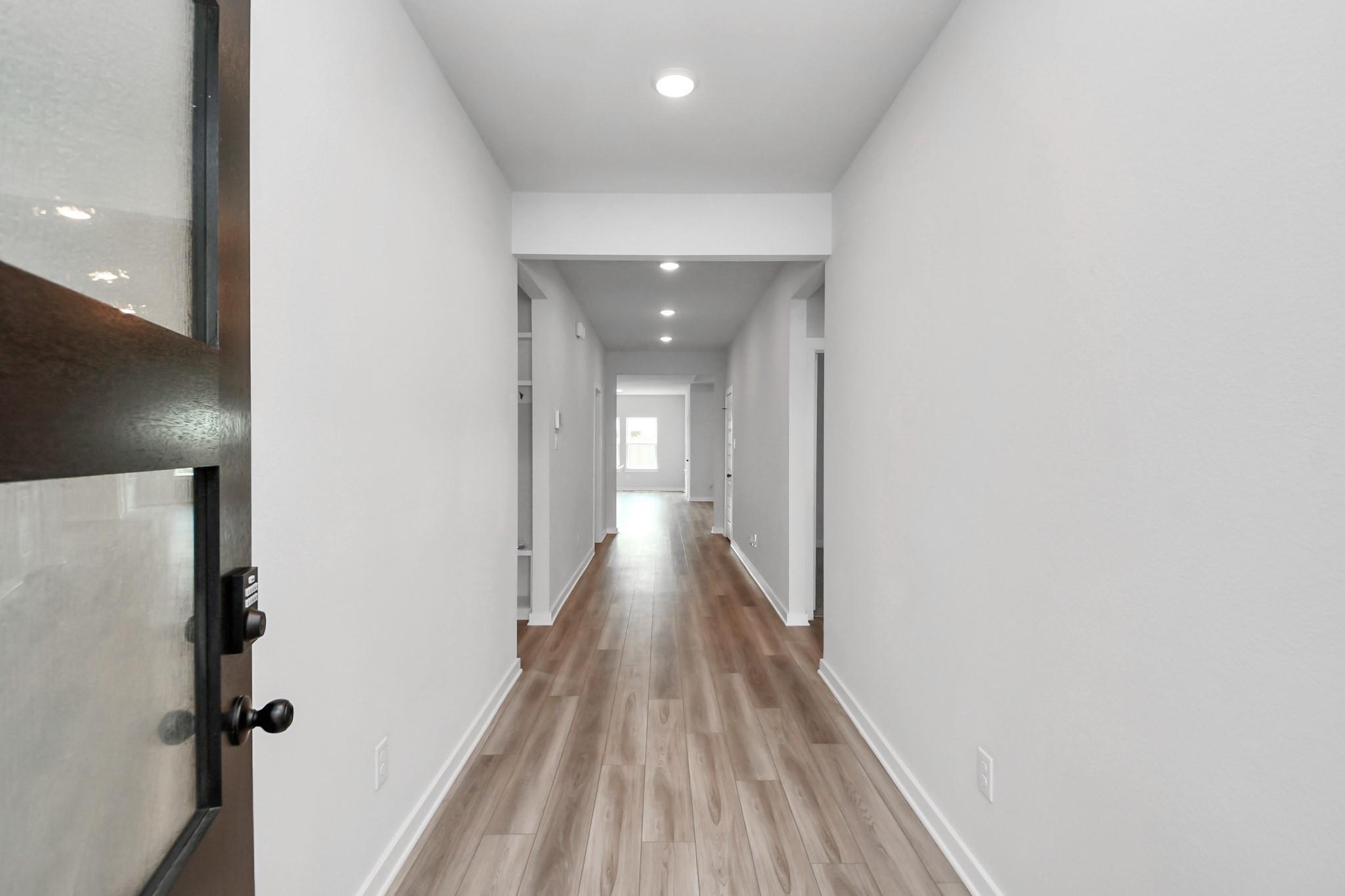Bright, modern entryway with wood-look flooring in The Everett C floor plan at River Ranch Meadows, Dayton, Texas.