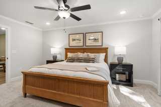 Master bedroom in The Washington H townhome by Davidson Homes, Marietta GA: wooden bed frame, plush bedding, ceiling fan, wall art