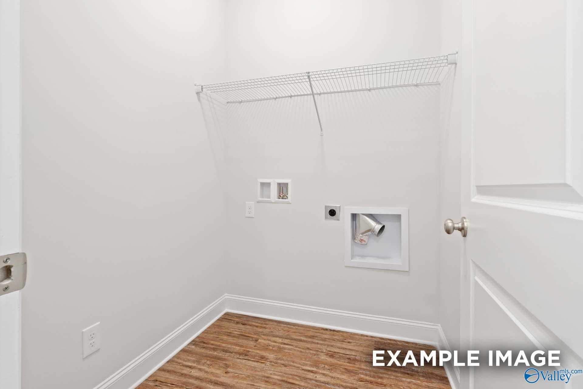 Spacious laundry closet with washer dryer hookups, wire shelving, and hardwood floors in Davidson Homes The Asheville C, Meridianville, Alabama