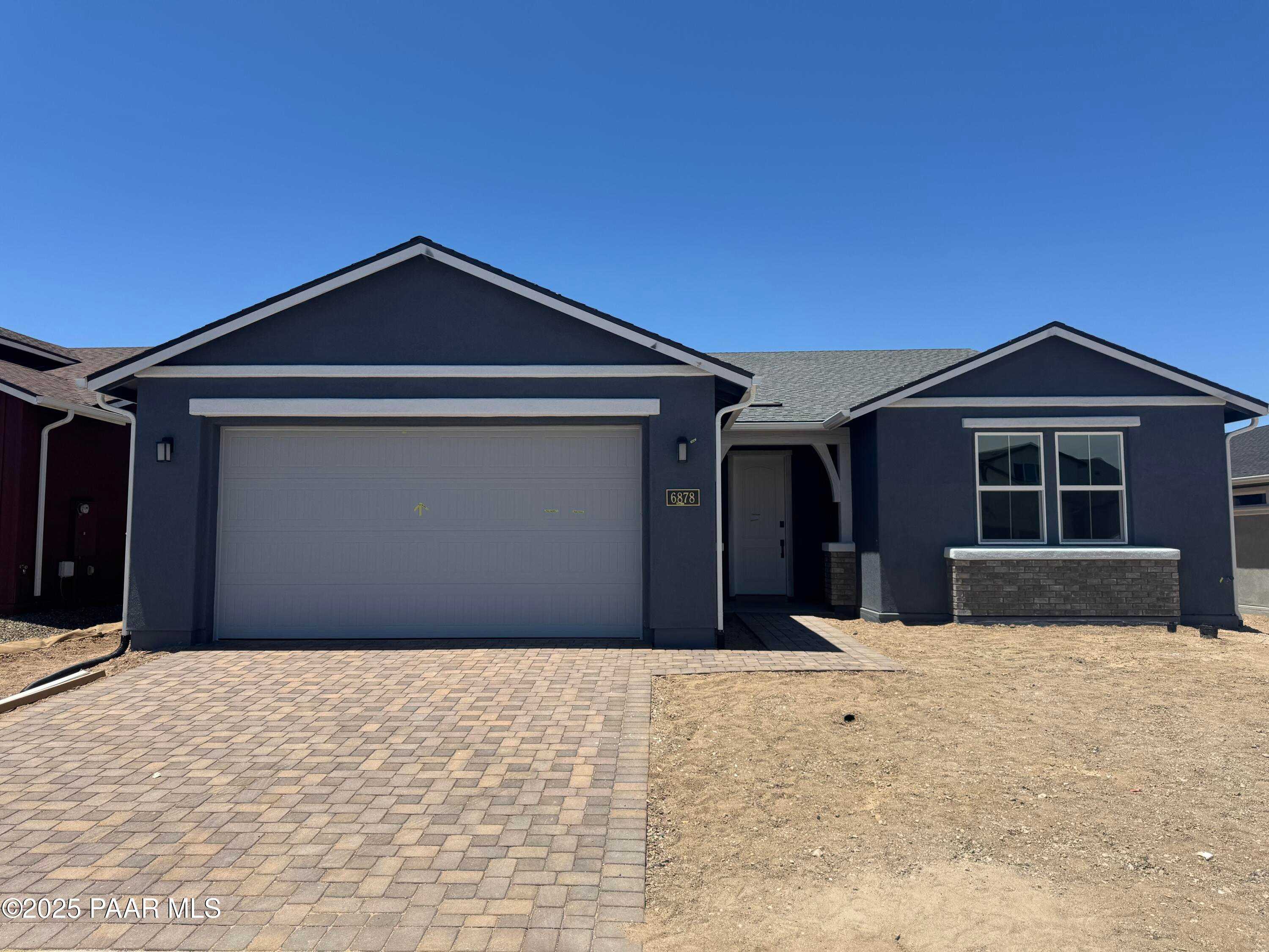 Modern gray single-story home with 3-car garage, paver driveway, and desert landscaping in Westwood, Prescott, Arizona - Davidson Homes Durango II A