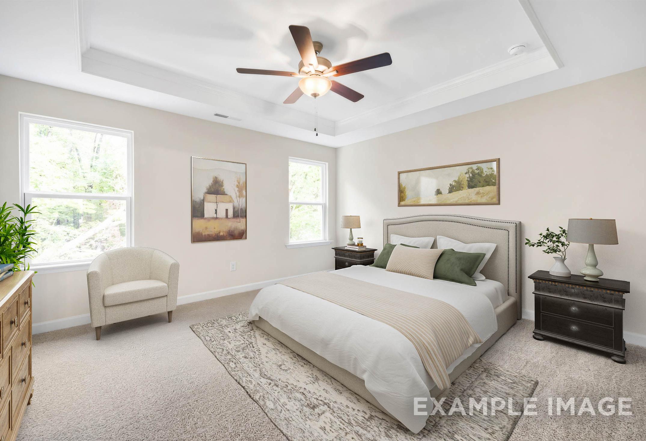 Spacious master bedroom in The Gavin A home design featuring king bed, neutral tones, ceiling fan, and tree-view windows