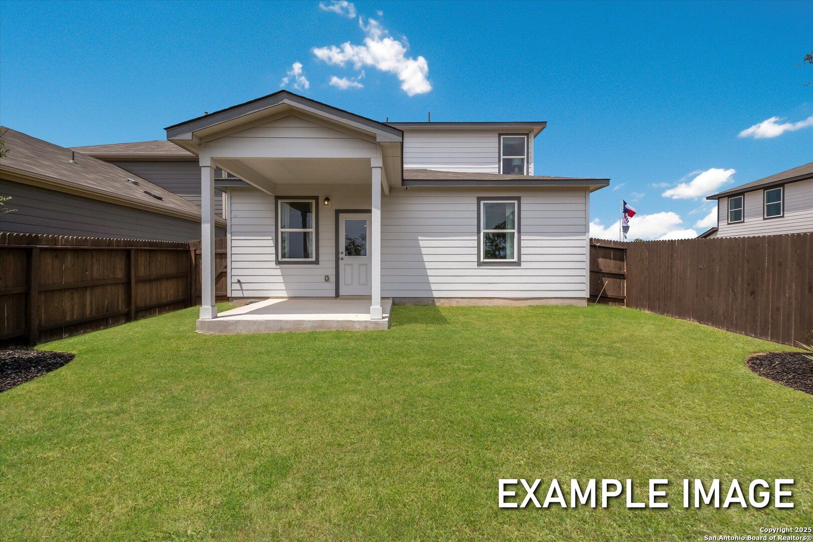 Two-story Sabine C home backyard featuring covered patio, lush green lawn, privacy fence in Agave, San Antonio, Texas by Davidson Homes