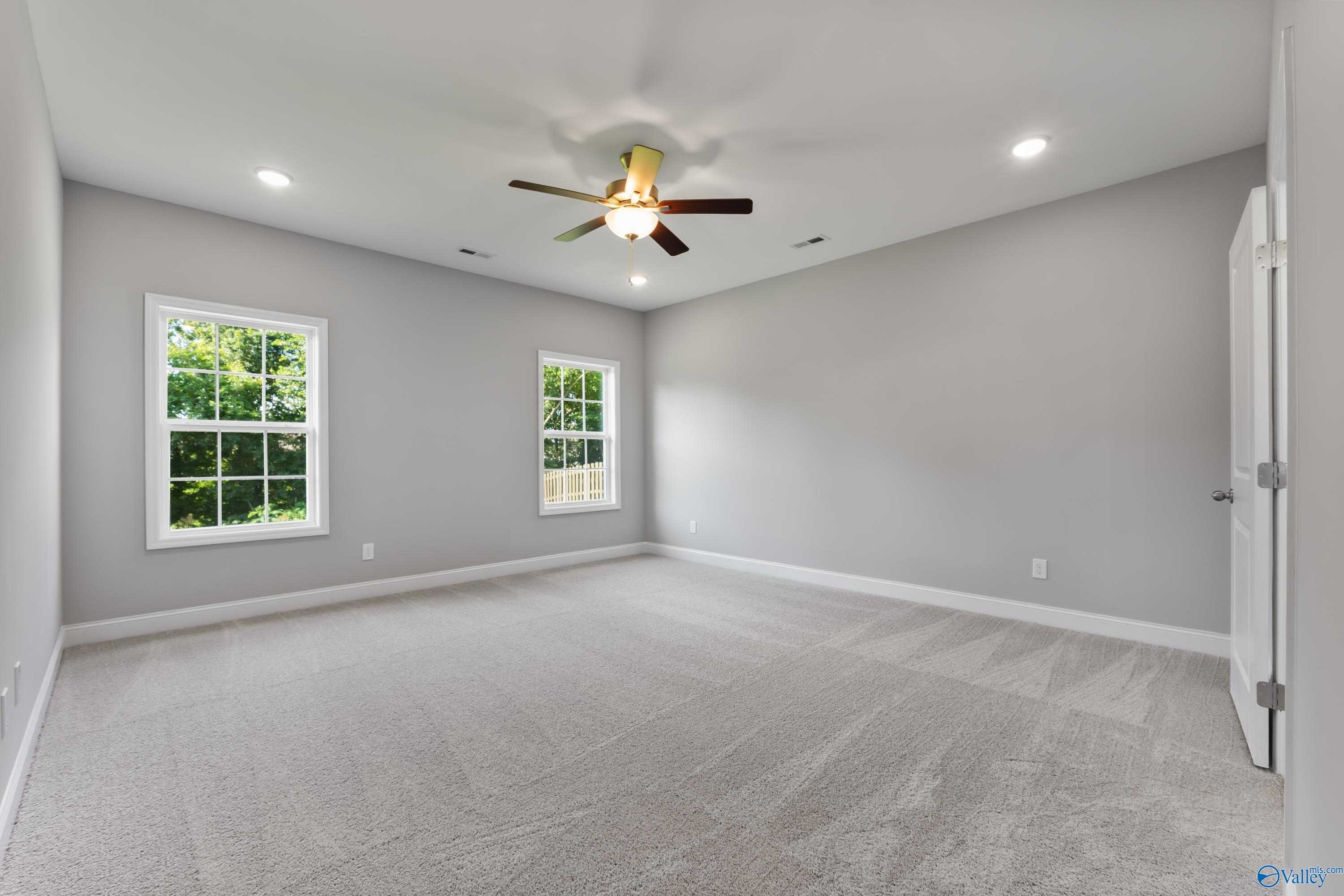 Bright secondary bedroom with gray walls, large windows, ceiling fan in Davidson Homes The Rockford, Harvest, Alabama