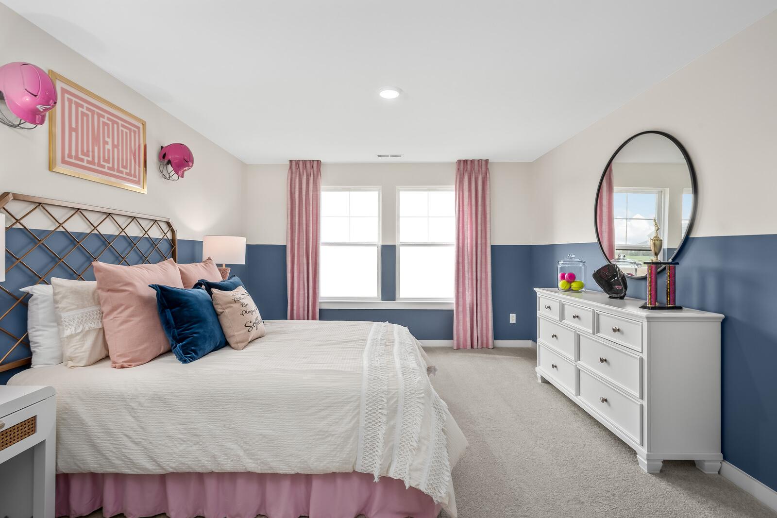 Cozy primary bedroom at Benders Cove in Mt. Juliet TN with navy headboard, pink pillows, white dresser, round mirror, and window views