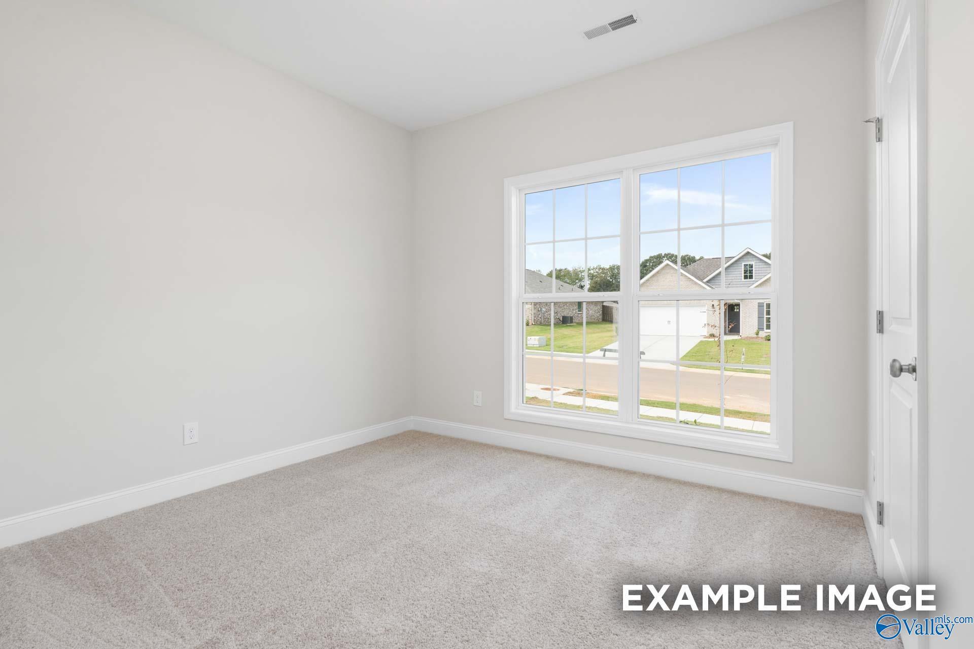 Bright bedroom with large window overlooking neighborhood in Davidson Homes The Franklin, Meridianville, Alabama