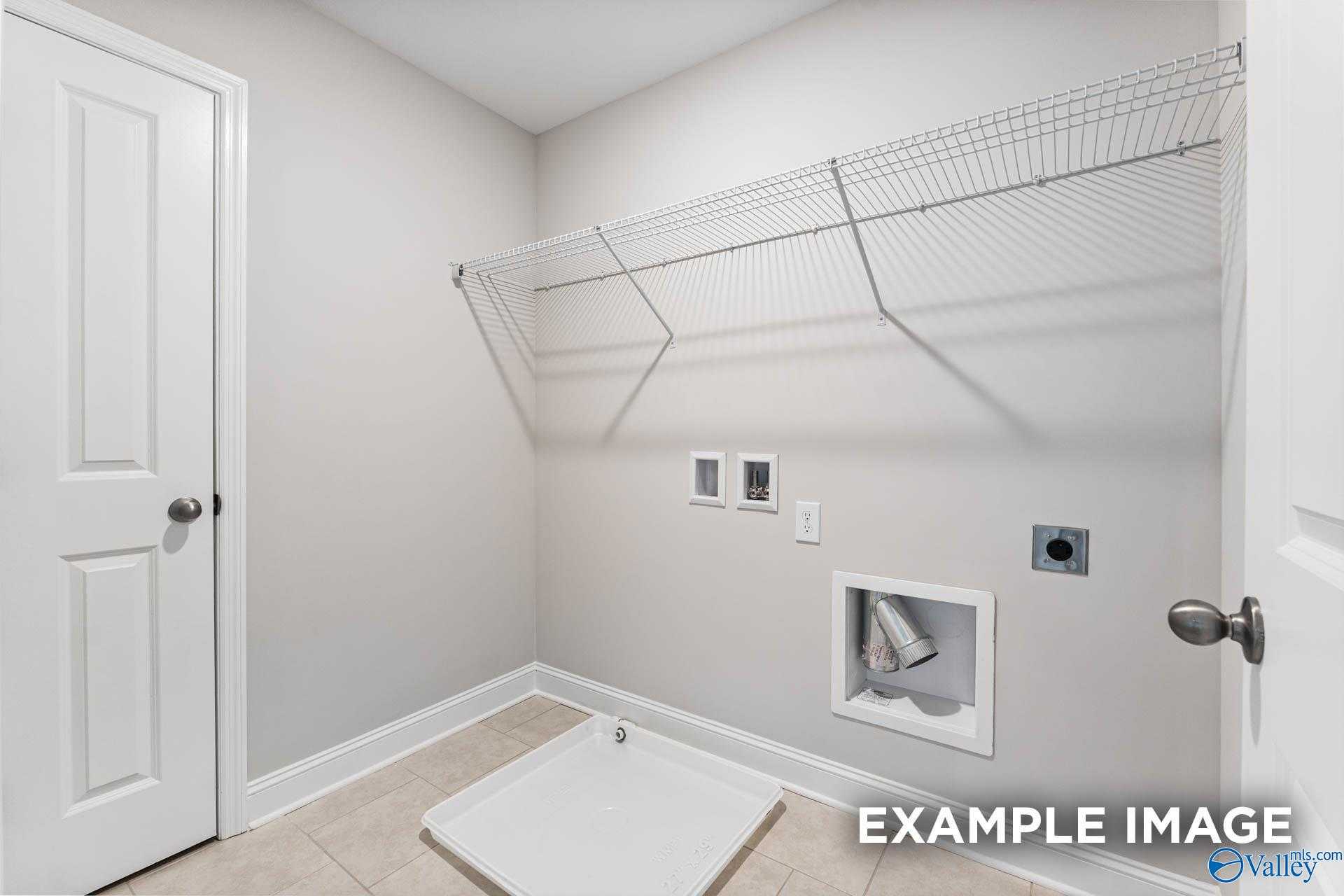 Spacious laundry room with wire shelving, utility sink and washer/dryer hookups in 5-bedroom Davidson Homes Madison A, Harvest, Alabama