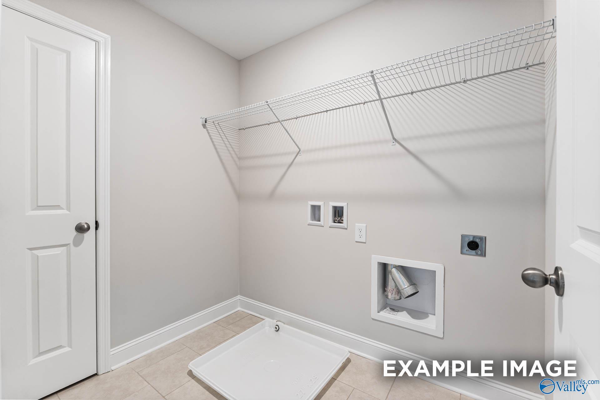 Laundry room with wire shelving and utility hookups in The Madison D floor plan by Davidson Homes in Evergreen Mill.