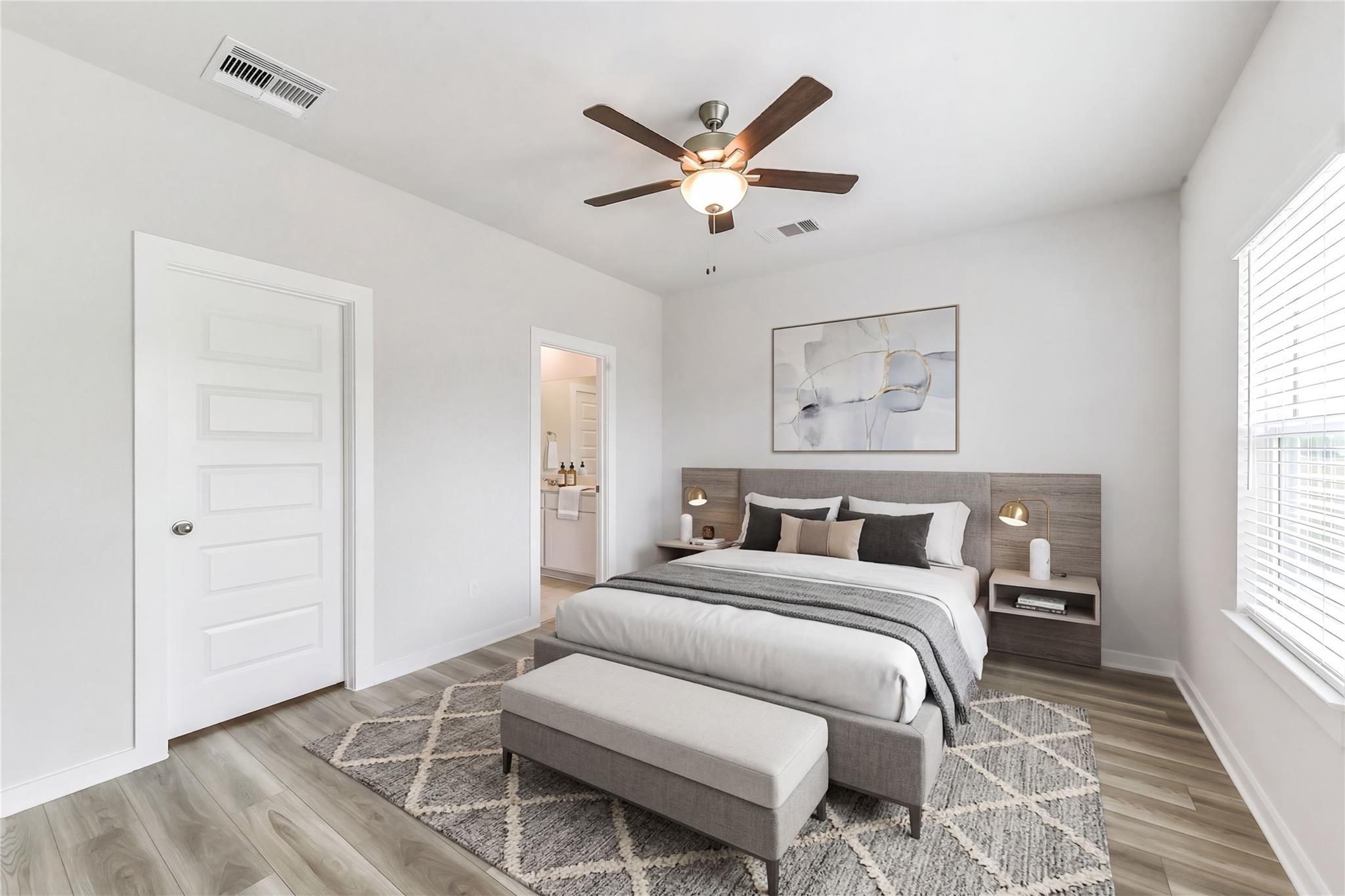 Serene master bedroom with upholstered bed, ceiling fan, en-suite bath in Davidson Homes The Frio G, Magnolia TX